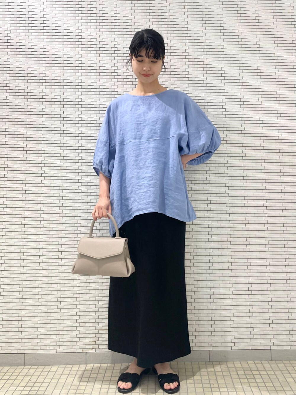 ブルー系のシャツ/ブラウス、ブラック系のサンダル、ブラック系のスカートを着用したレディースの夏コーディネートの4枚目の写真
