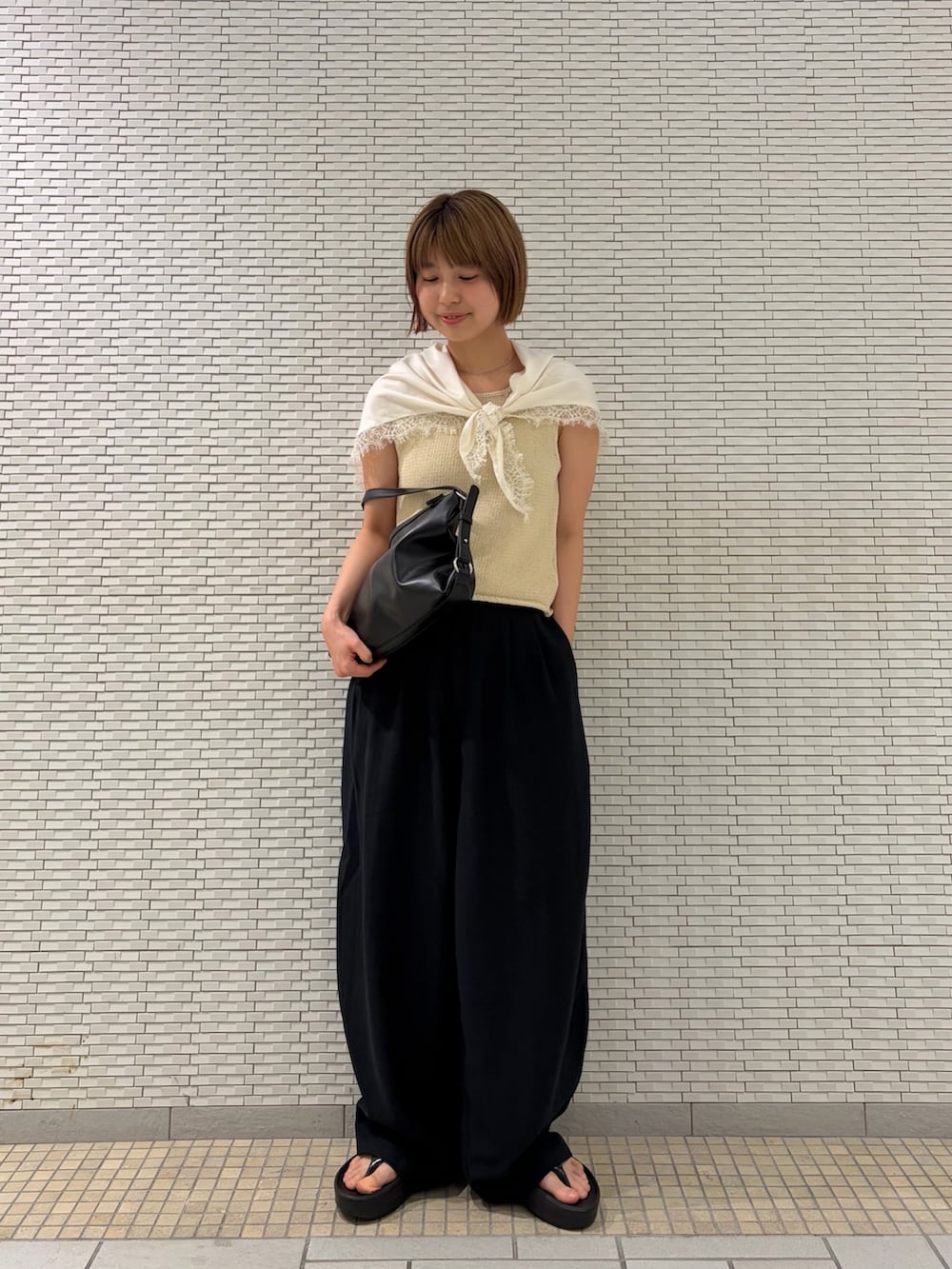 ブラック系のショルダーバッグ、ブルー系のその他パンツ、ホワイト系のベストを着用したレディースの夏コーディネートの2枚目の写真