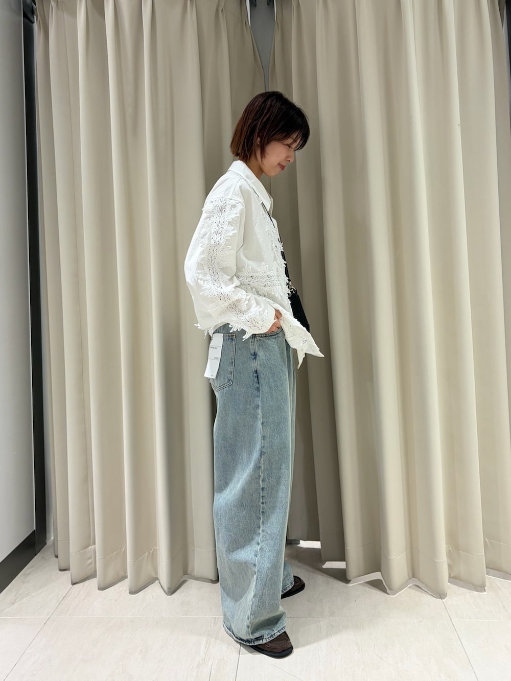 ホワイト系のシャツ/ブラウス、ブルー系のデニムパンツ、ブラウン系のローファーを着用したレディースの春コーディネートの2枚目の写真