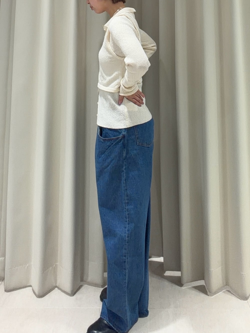 ホワイト系のニット/セーター、ブルー系のデニムパンツ、ブラック系のその他シューズを着用したレディースの春コーディネートの2枚目の写真