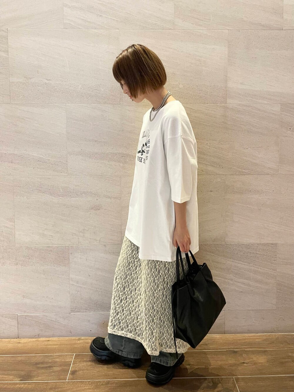 ブルー系のデニムパンツ、ホワイト系のTシャツ/カットソー、ブラック系のスニーカーを着用したレディースの夏コーディネートの3枚目の写真