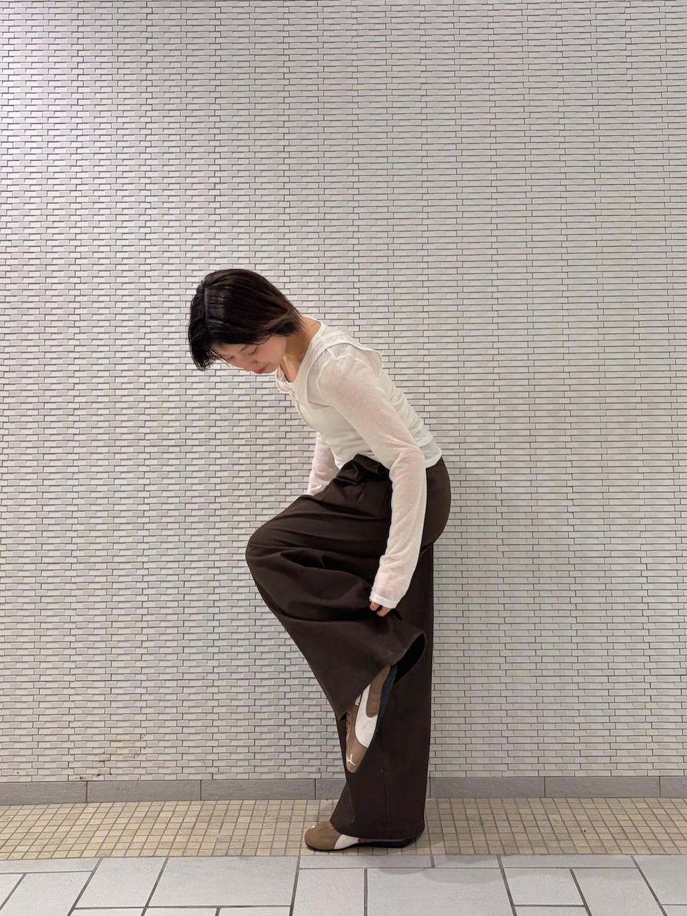 ホワイト系のTシャツ/カットソー、ブラウン系のその他パンツ、ブラウン系のスニーカーを着用したレディースの春コーディネートの2枚目の写真