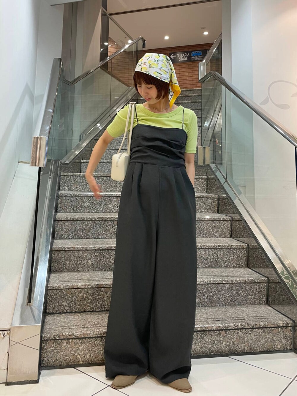 ホワイト系のショルダーバッグ、ベージュ系のその他シューズ、グリーン系のTシャツ/カットソーを着用したレディースの夏コーディネートの2枚目の写真