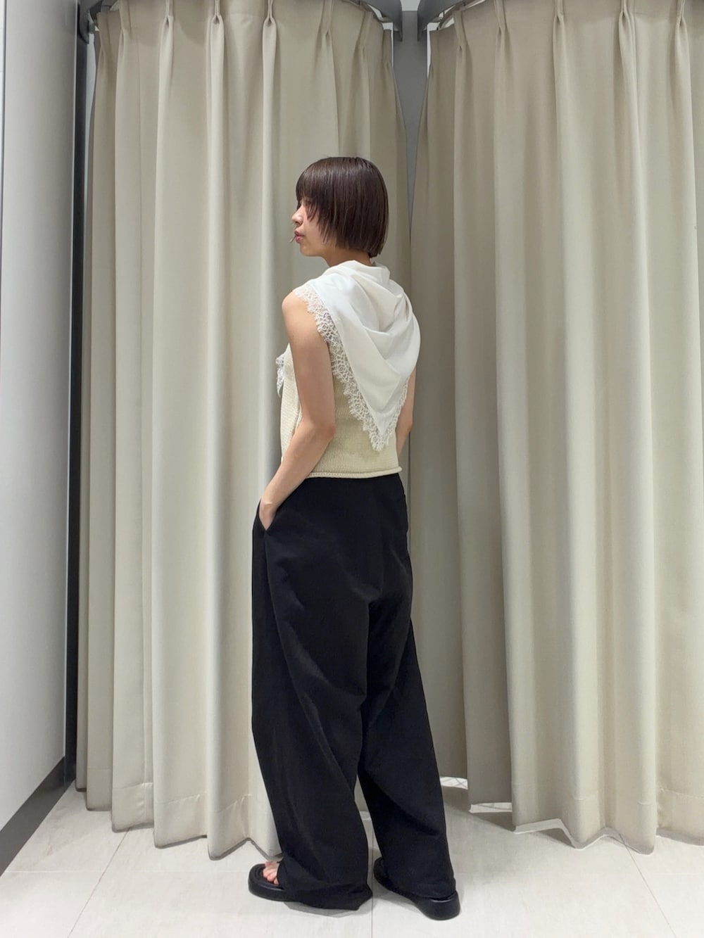 ブラック系のその他パンツ、ブラック系のサンダル、ホワイト系のベストを着用したレディースの夏コーディネートの2枚目の写真
