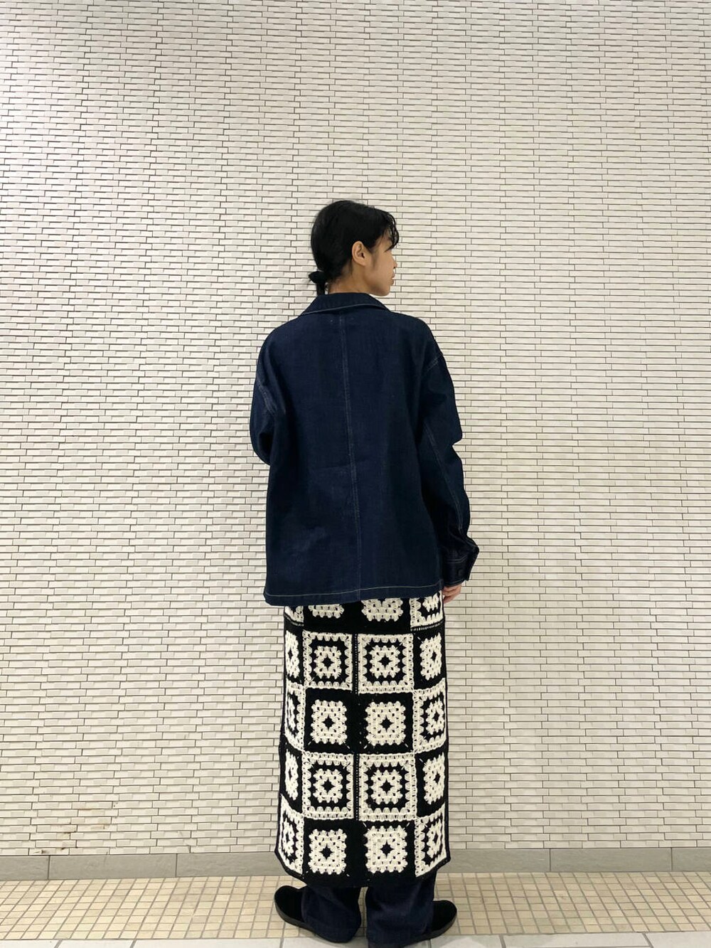 ブラック系のその他シューズ、ブルー系のデニムパンツ、ホワイト系のワンピースを着用したレディースの秋コーディネートの4枚目の写真