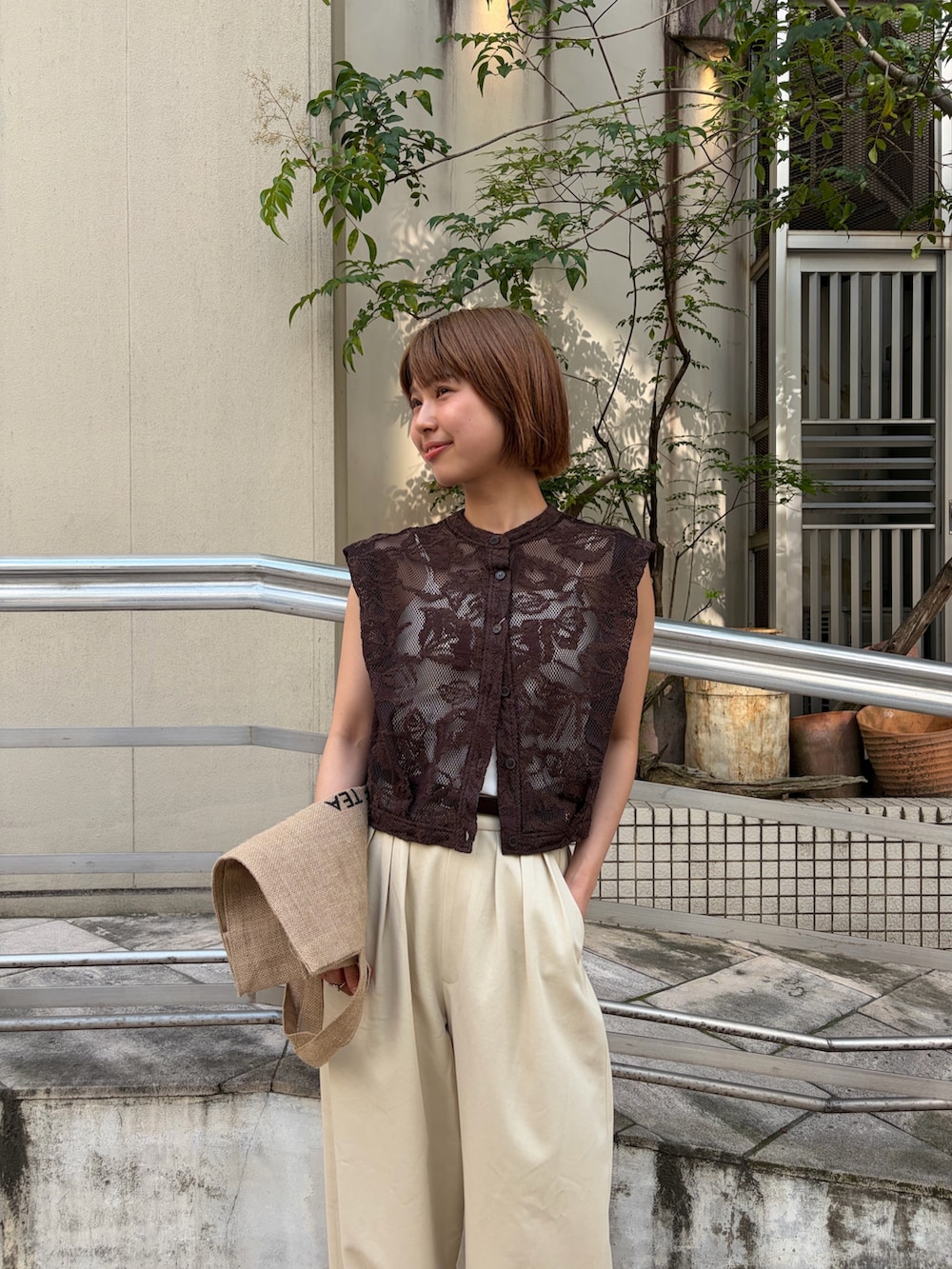 ブラウン系のシャツ/ブラウス、ベージュ系のその他パンツ、ホワイト系のキャミソールを着用したレディースの夏コーディネートの2枚目の写真