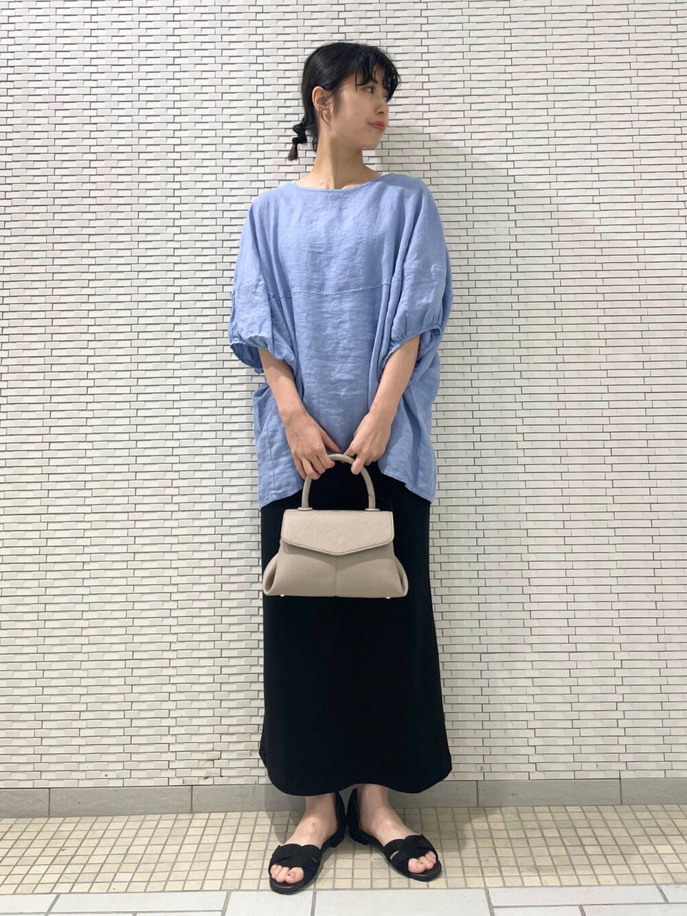 ブルー系のシャツ/ブラウス、ブラック系のサンダル、ブラック系のスカートを着用したレディースの夏コーディネートの2枚目の写真