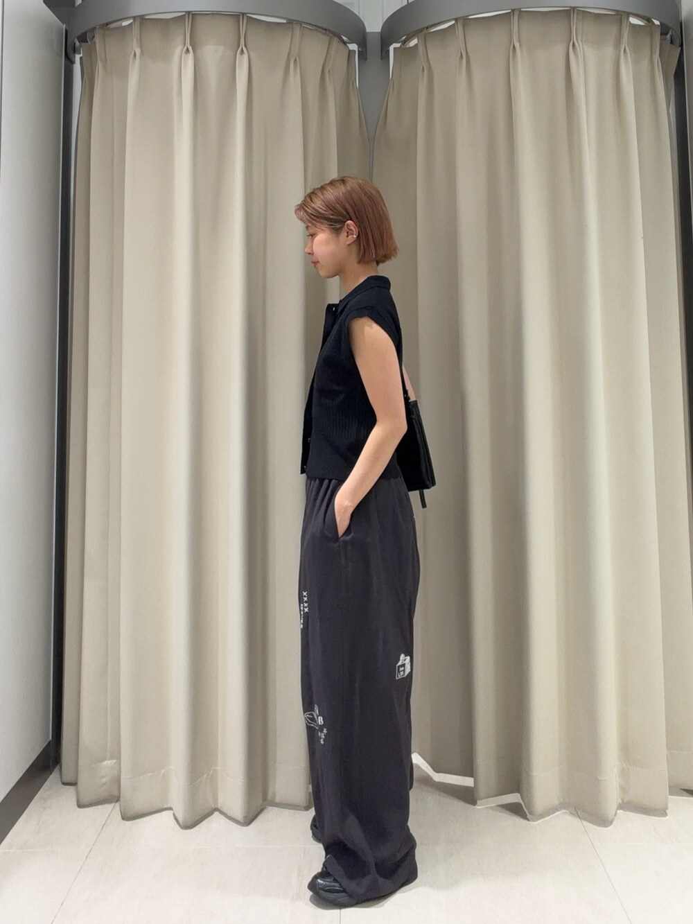 ブラック系のニット/セーター、グレー系のその他パンツ、ブラック系のショルダーバッグを着用したレディースの春コーディネートの2枚目の写真