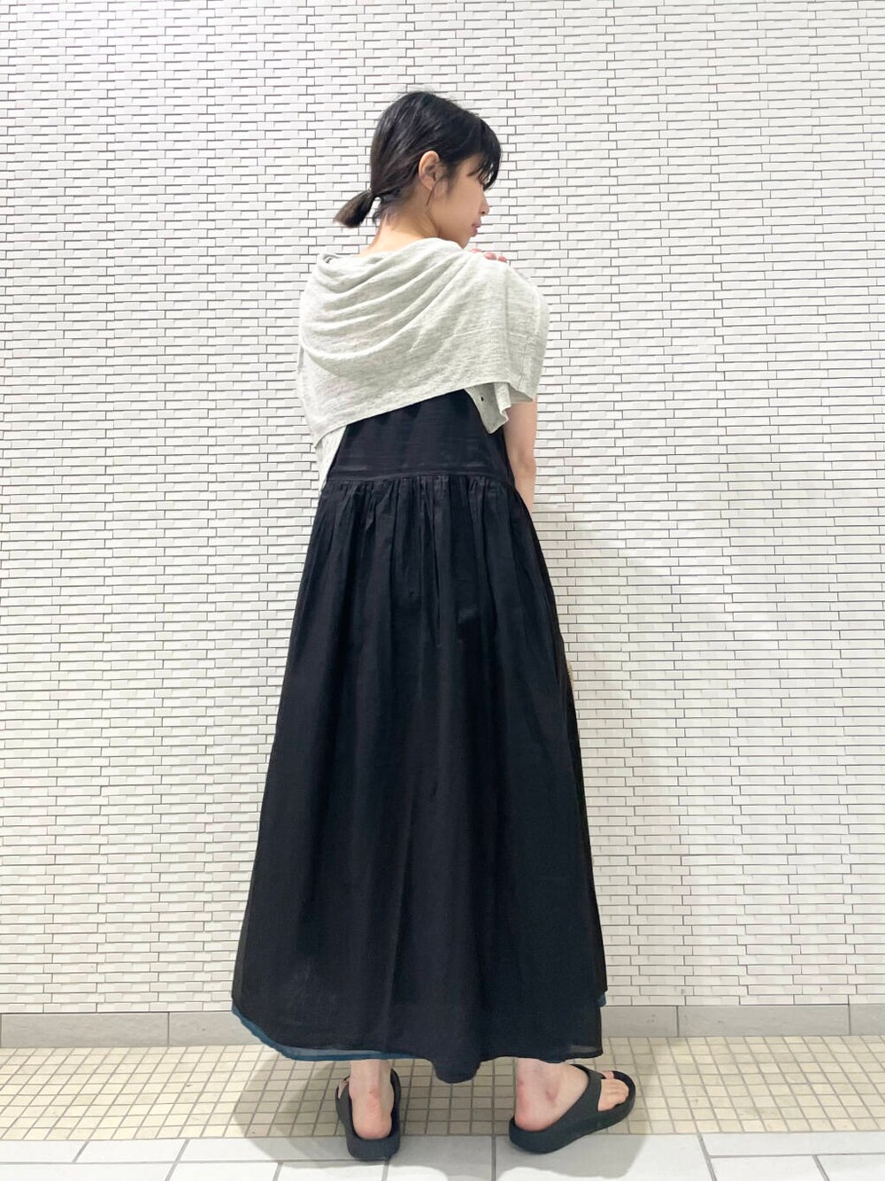 グレー系のカーディガン/ボレロ、ブラック系のワンピース、グレー系のトートバッグを着用したレディースの夏コーディネートの2枚目の写真