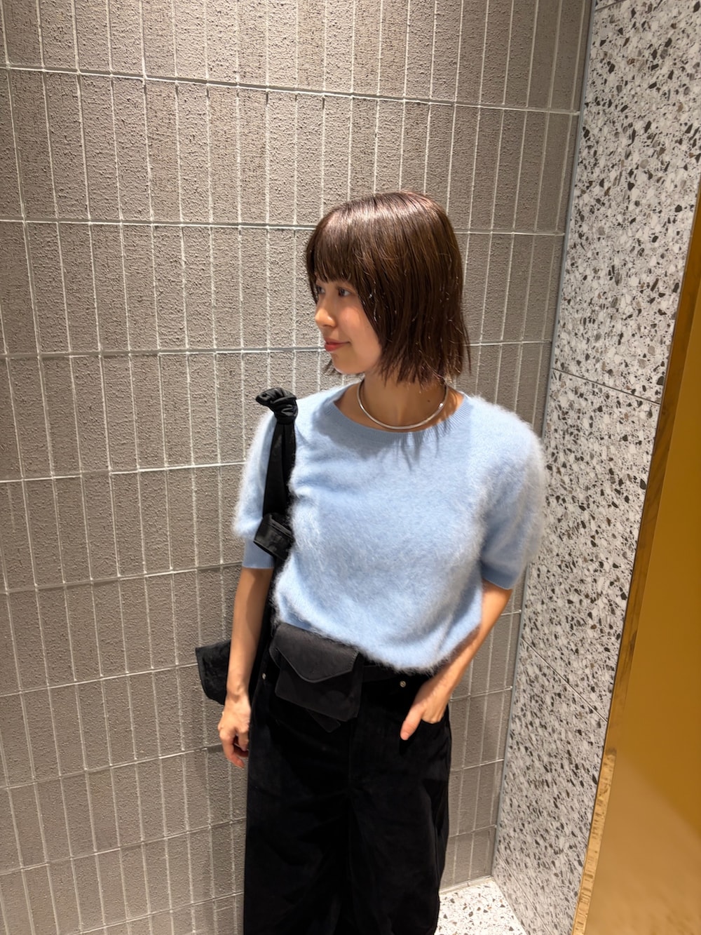 ブルー系のニット/セーター、ブラック系のその他パンツ、ブラック系のボディバッグ/ウエストポーチを着用したレディースの秋コーディネートの2枚目の写真