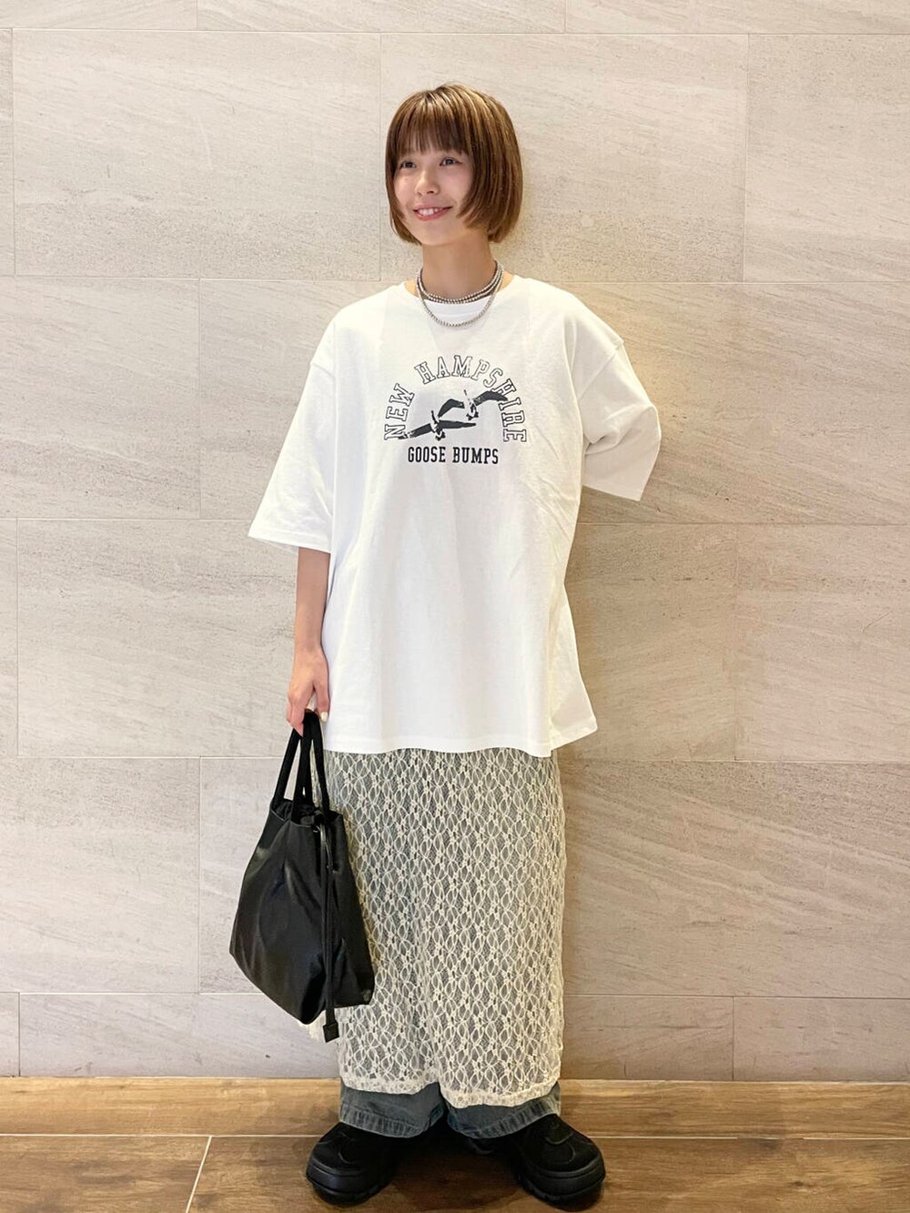 ブルー系のデニムパンツ、ホワイト系のTシャツ/カットソー、ブラック系のスニーカーを着用したレディースの夏コーディネートの2枚目の写真