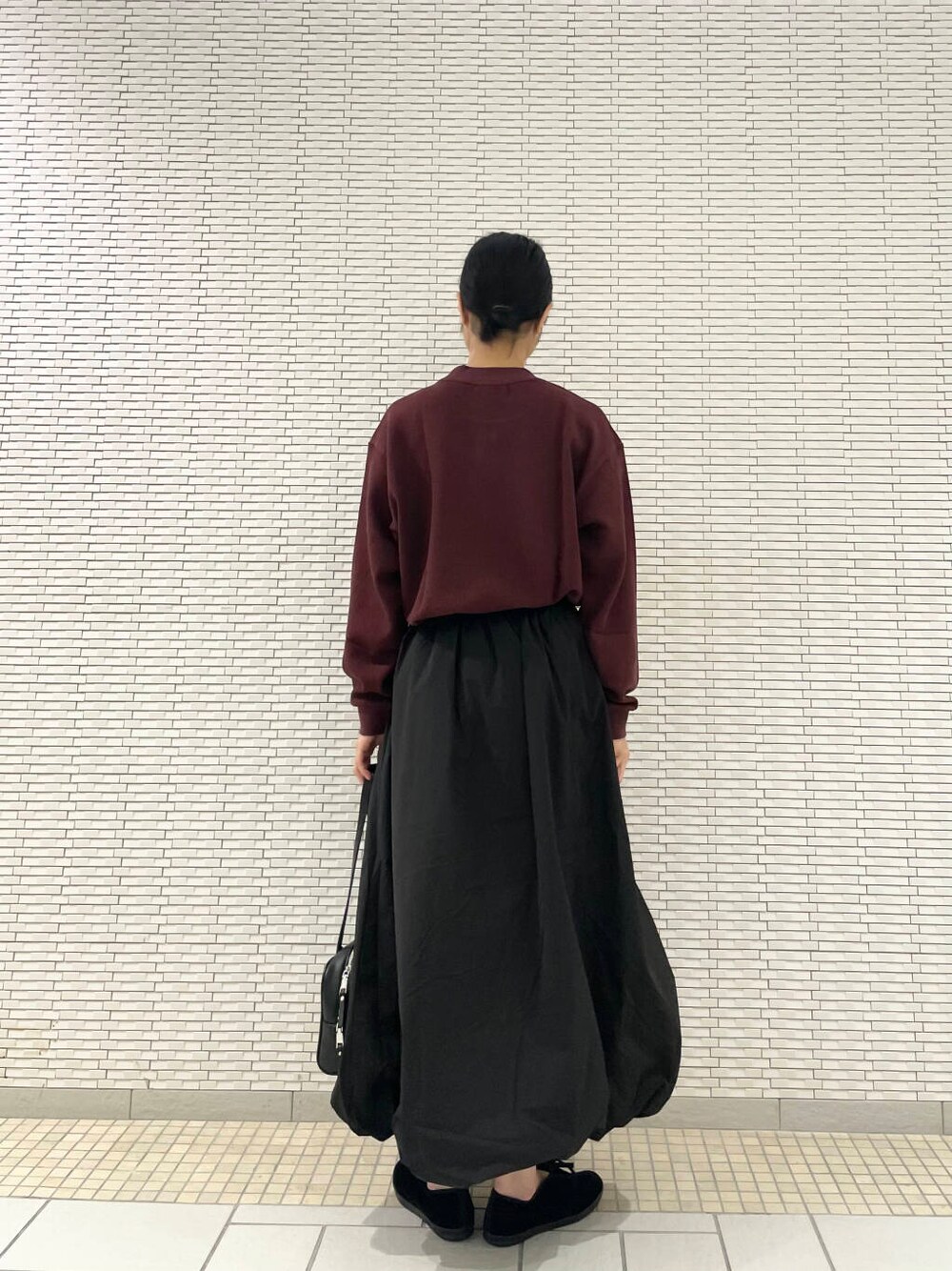 ブラック系のその他シューズ、ブラック系のスカート、レッド系のTシャツ/カットソーを着用したレディースの秋コーディネートの3枚目の写真