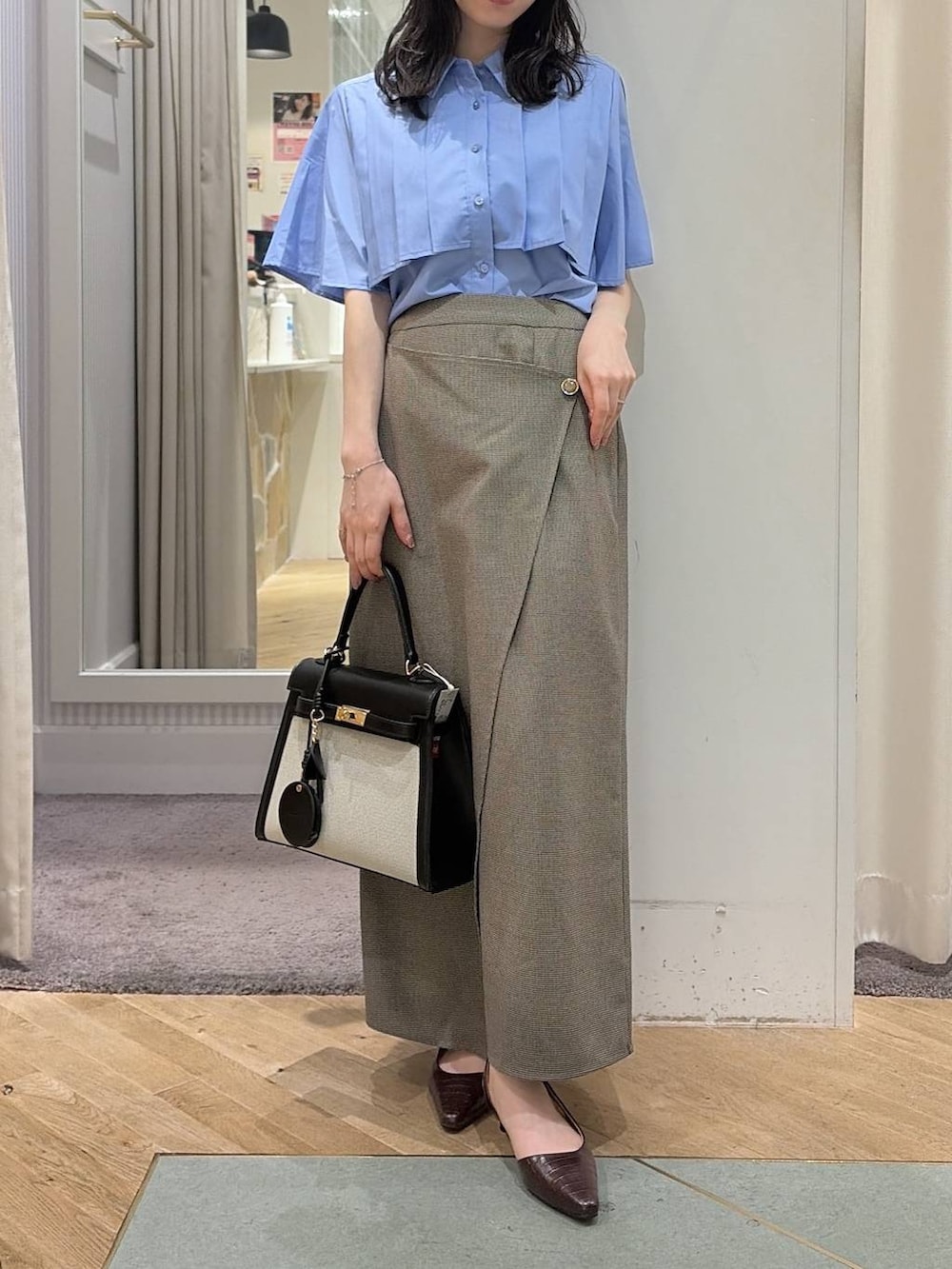 ベージュ系のスカート、ブルー系のシャツ/ブラウス、ブラウン系のパンプスを着用したレディースの夏コーディネートの9枚目の写真