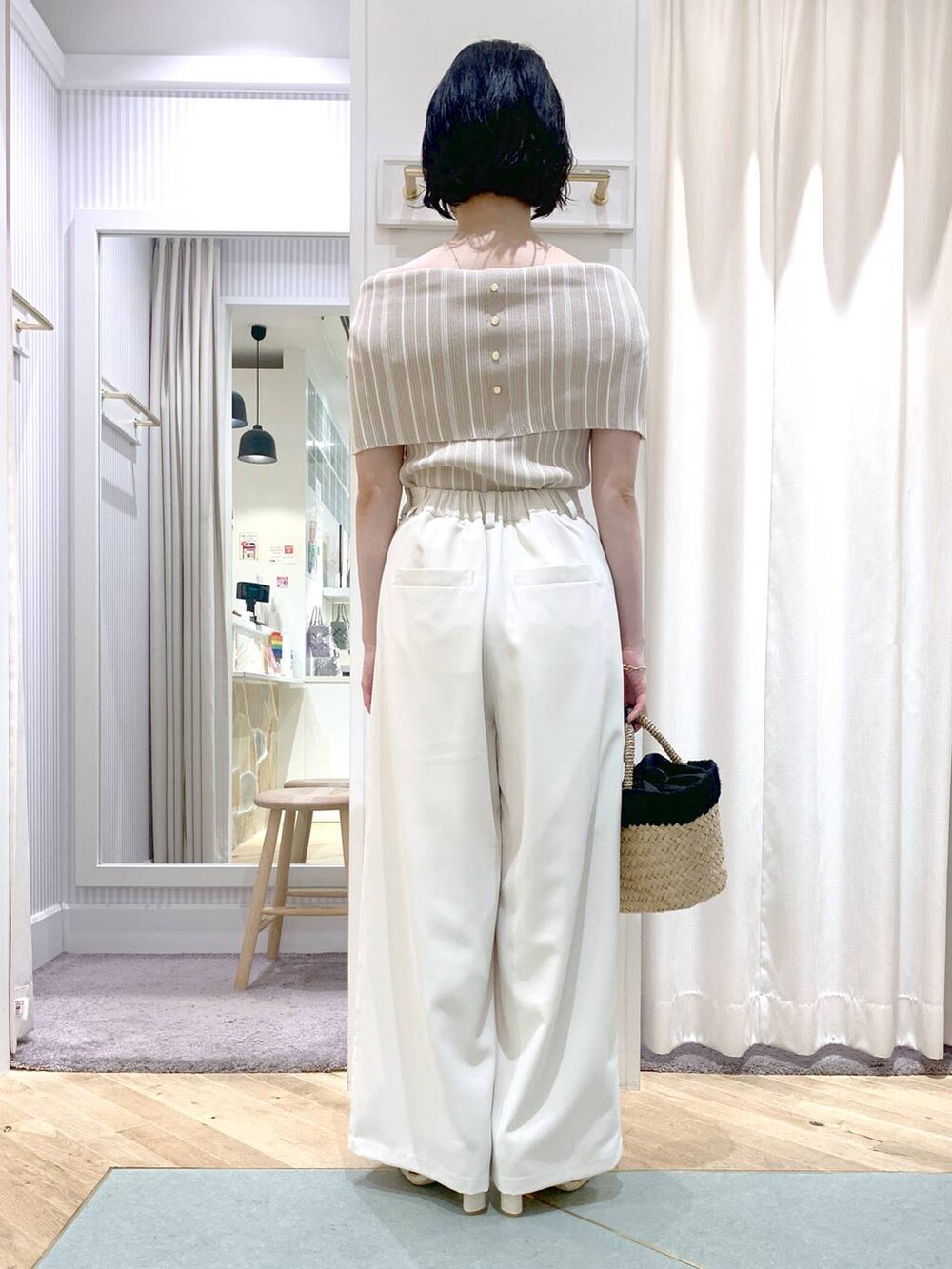 ベージュ系のかごバッグ、ホワイト系のサンダル、ホワイト系のスラックスを着用したレディースの夏コーディネートの4枚目の写真