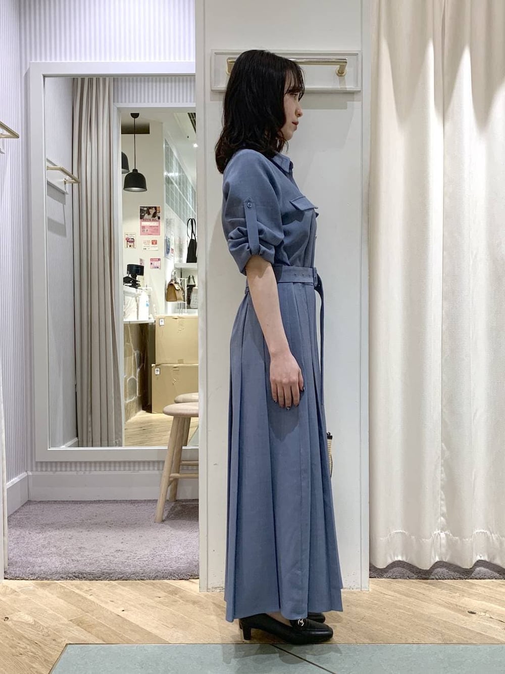 ブラック系のトートバッグ、ブルー系のワンピースを着用したレディースの春コーディネートの4枚目の写真