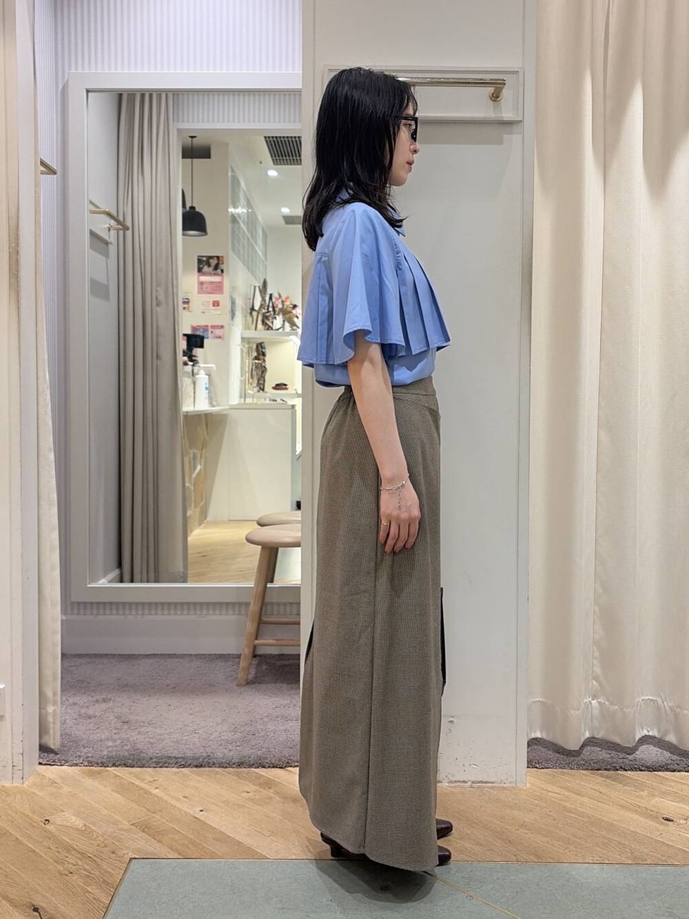 ベージュ系のスカート、ブルー系のシャツ/ブラウス、ブラウン系のパンプスを着用したレディースの夏コーディネートの3枚目の写真