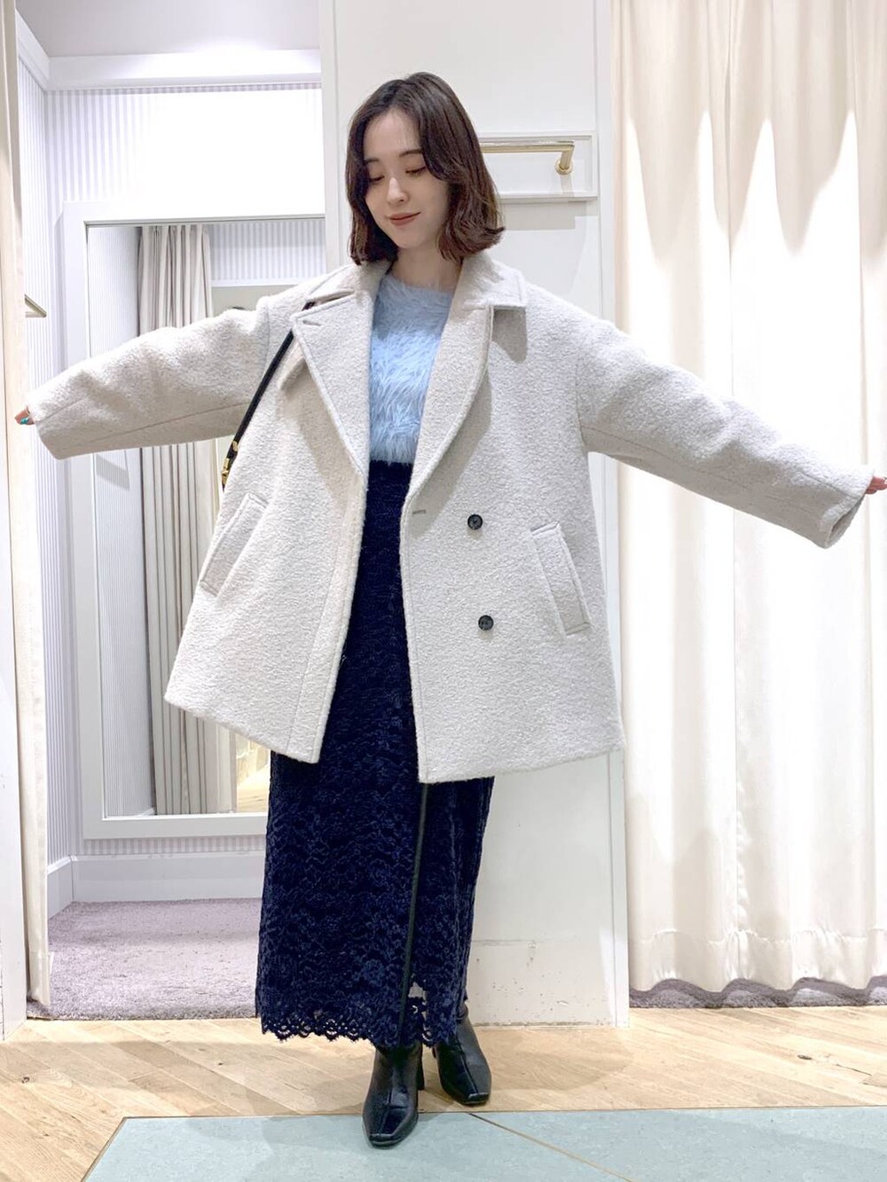 ブラック系のショルダーバッグ、グレー系のピーコート、ブラック系のブーツを着用したレディースの秋コーディネートの2枚目の写真