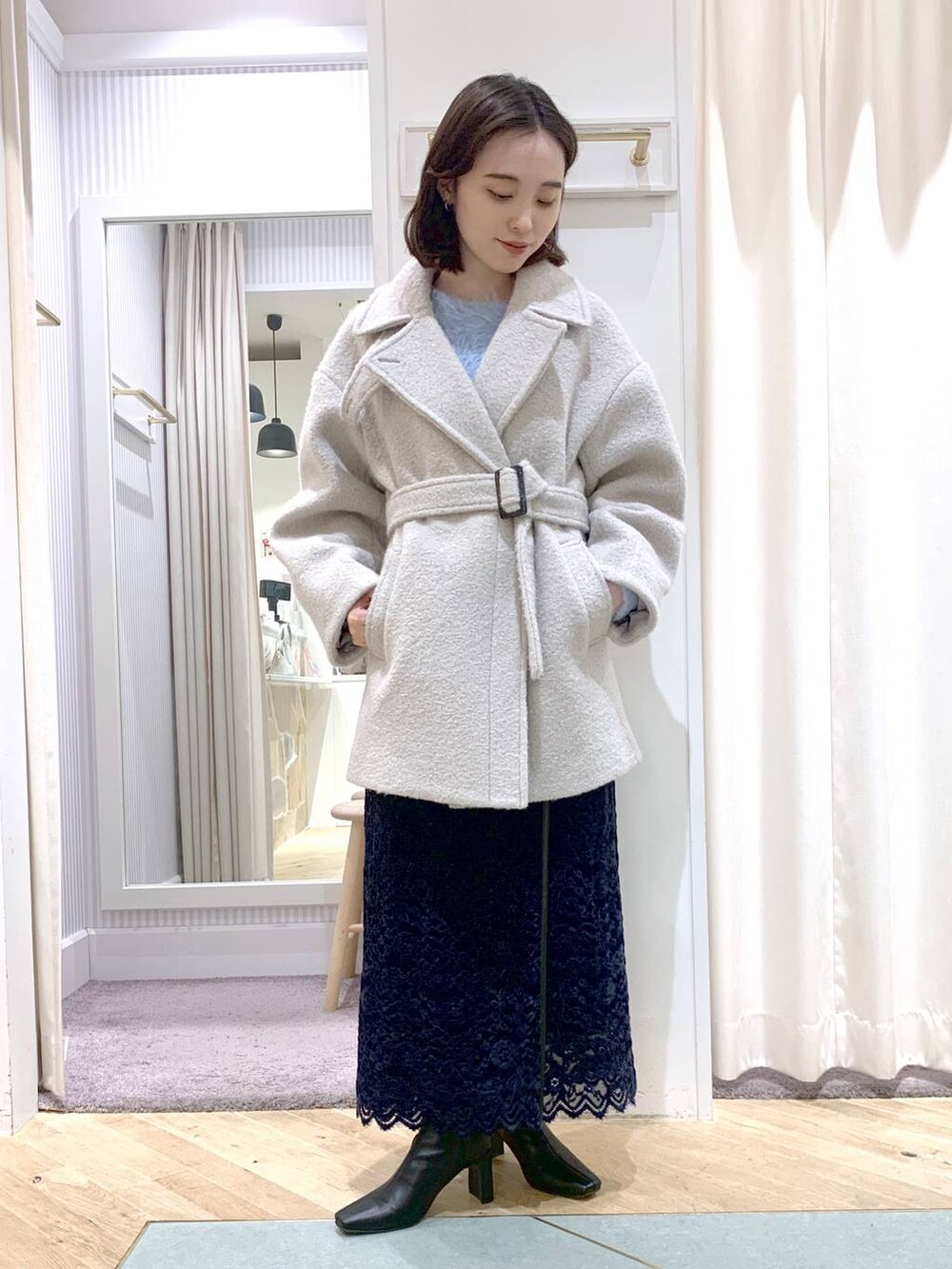 ブラック系のショルダーバッグ、グレー系のピーコート、ブラック系のブーツを着用したレディースの秋コーディネートの6枚目の写真