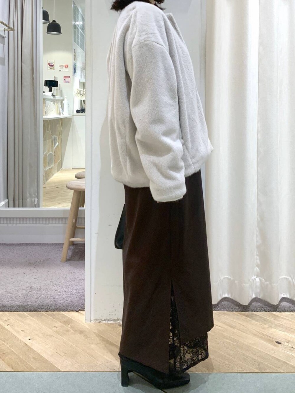 ベージュ系のブルゾン、ブラック系のブーツ、ブラック系のハンドバッグを着用したレディースの秋コーディネートの4枚目の写真