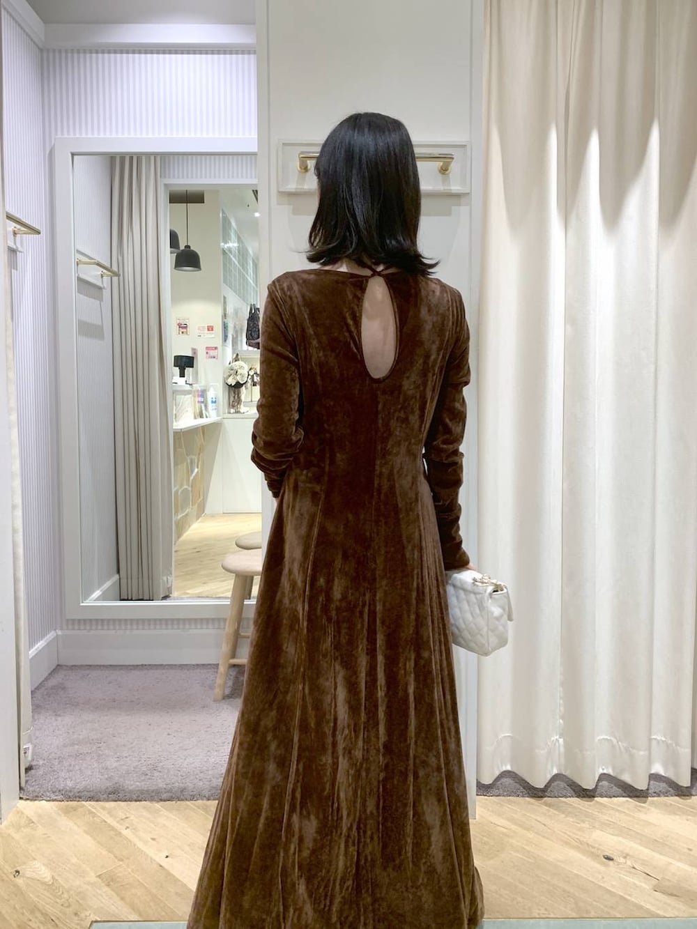 ブラック系のブーツ、ホワイト系のショルダーバッグ、ブラウン系のワンピースを着用したレディースの秋コーディネートの6枚目の写真