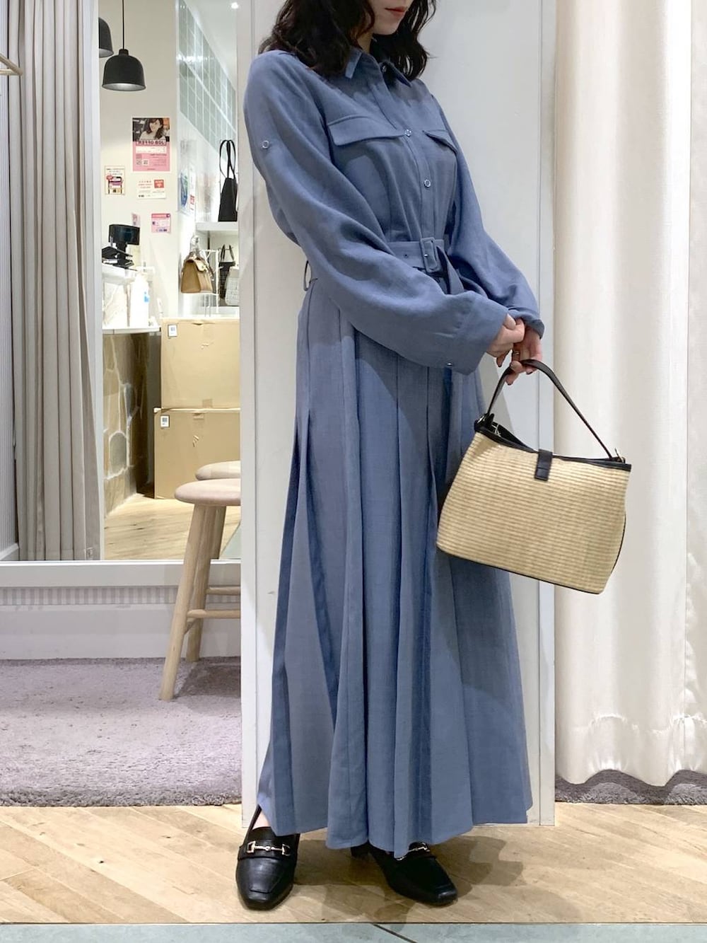 ブラック系のトートバッグ、ブルー系のワンピースを着用したレディースの春コーディネートの3枚目の写真