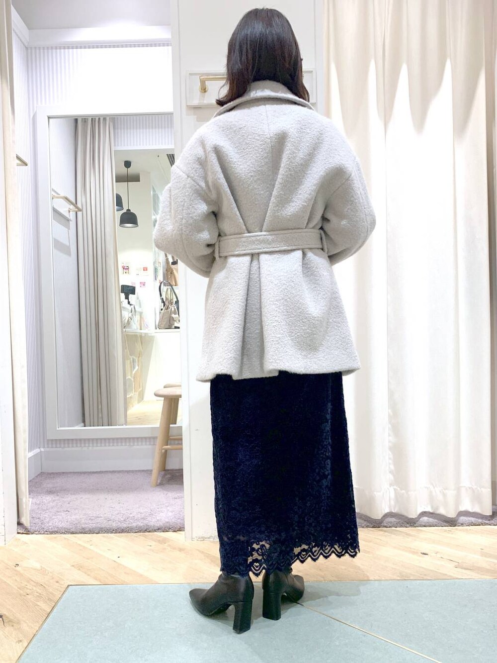 ブラック系のショルダーバッグ、グレー系のピーコート、ブラック系のブーツを着用したレディースの秋コーディネートの8枚目の写真