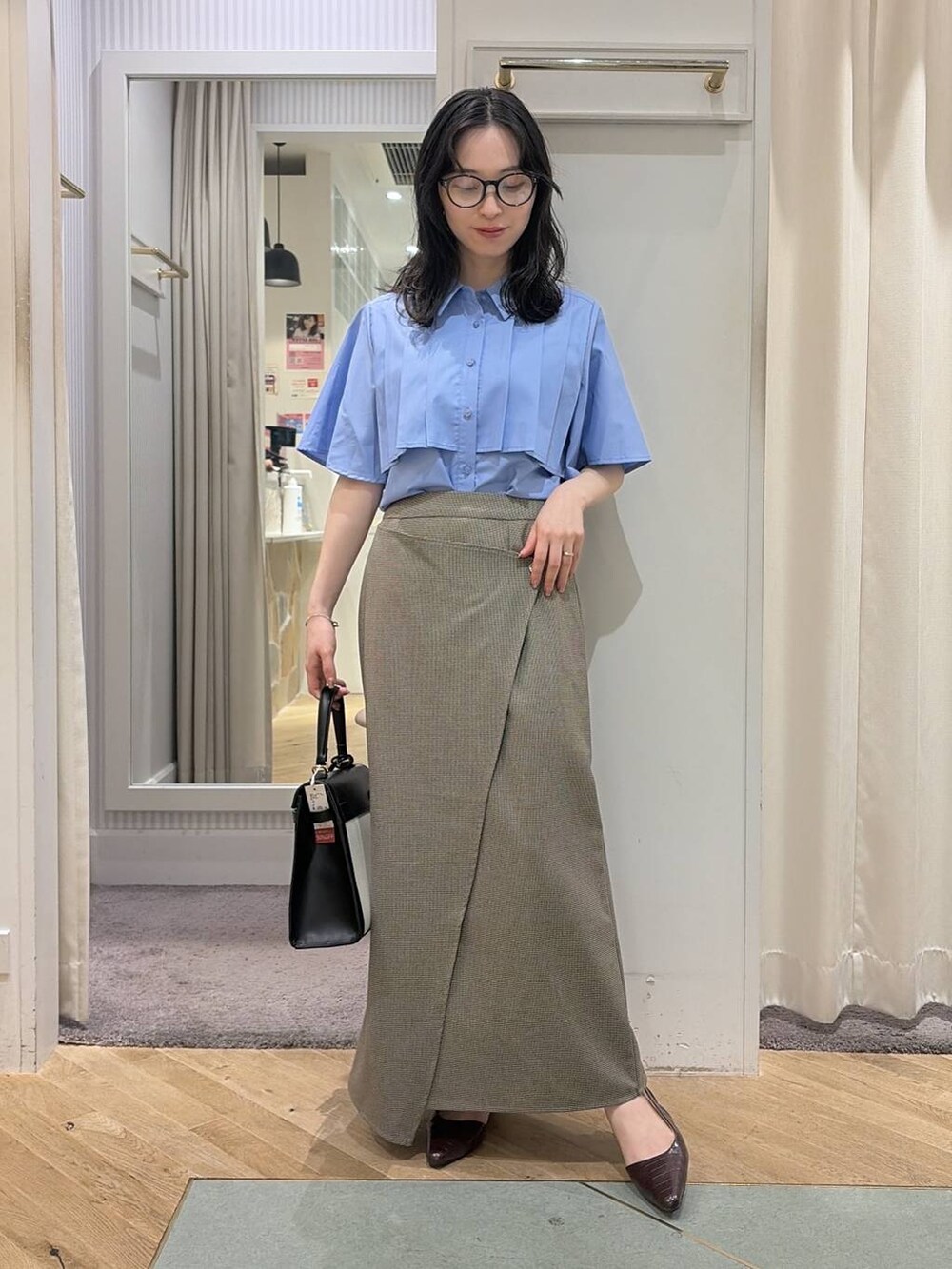 ベージュ系のスカート、ブルー系のシャツ/ブラウス、ブラウン系のパンプスを着用したレディースの夏コーディネートの7枚目の写真