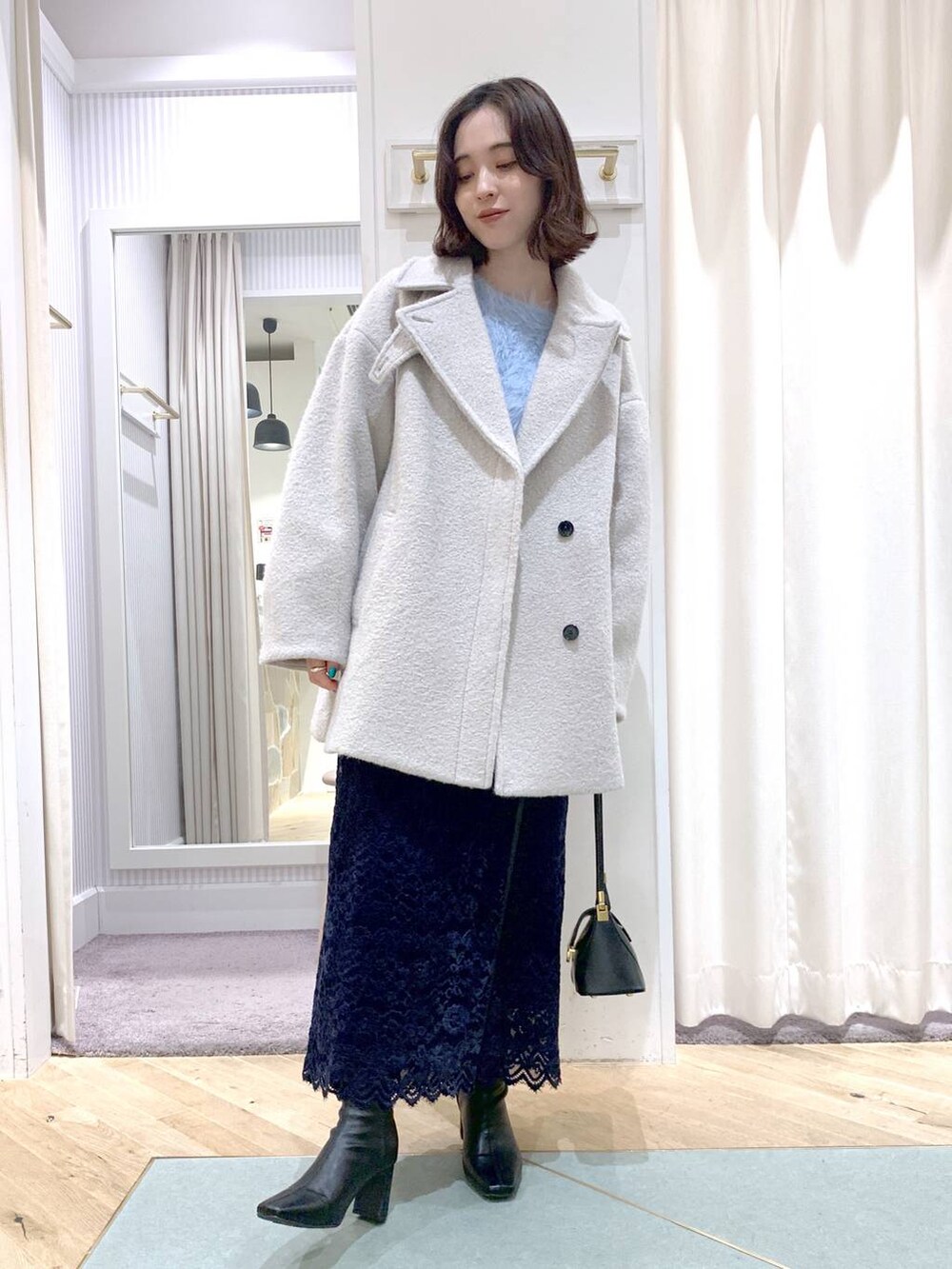 ブラック系のショルダーバッグ、グレー系のピーコート、ブラック系のブーツを着用したレディースの秋コーディネートの5枚目の写真