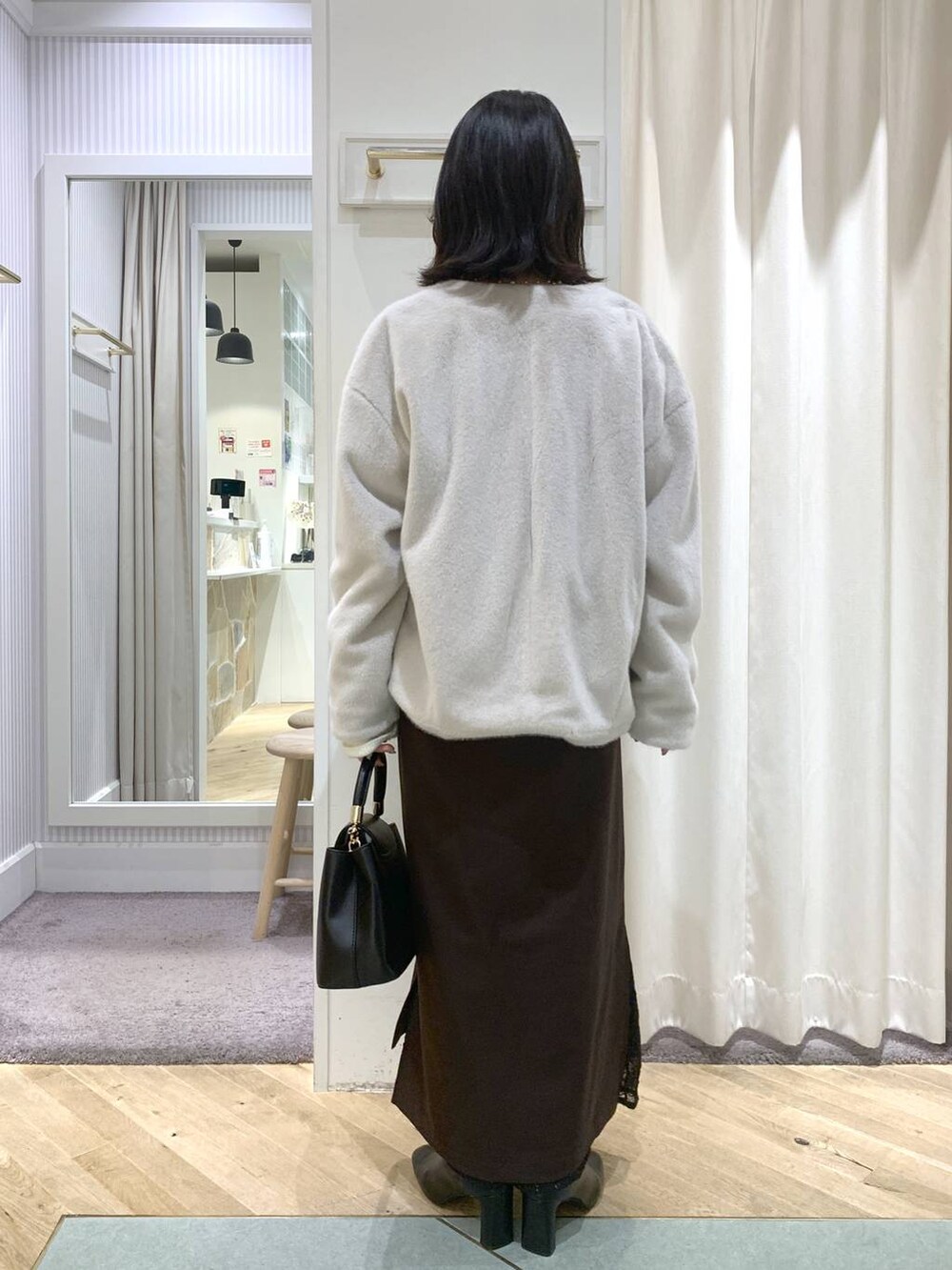 ベージュ系のブルゾン、ブラック系のブーツ、ブラック系のハンドバッグを着用したレディースの秋コーディネートの5枚目の写真