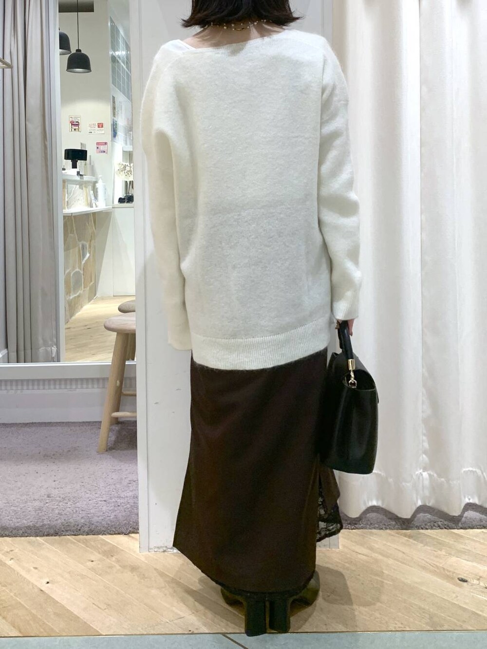 ベージュ系のブルゾン、ブラック系のブーツ、ブラック系のハンドバッグを着用したレディースの秋コーディネートの7枚目の写真