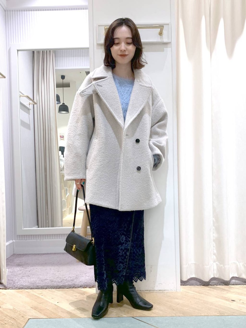ブラック系のショルダーバッグ、グレー系のピーコート、ブラック系のブーツを着用したレディースの秋コーディネートの4枚目の写真