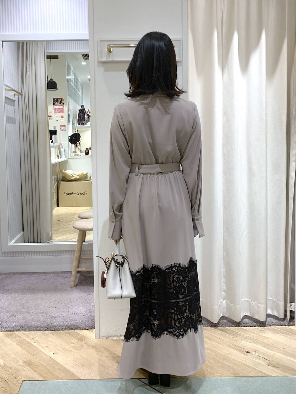 レッド系のピーコート、ブラック系のブーツ、ホワイト系のハンドバッグを着用したレディースの冬コーディネートの5枚目の写真