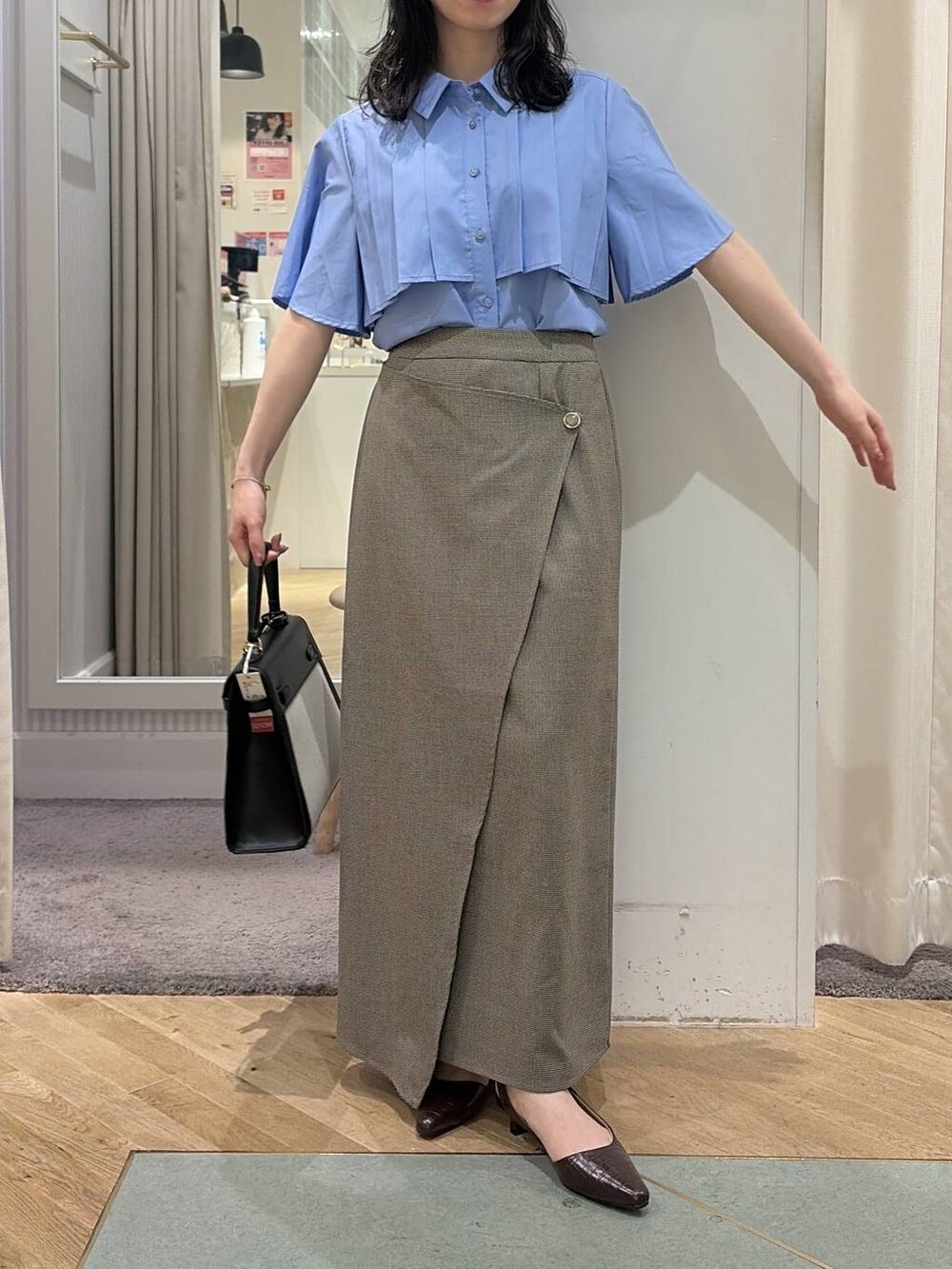 ベージュ系のスカート、ブルー系のシャツ/ブラウス、ブラウン系のパンプスを着用したレディースの夏コーディネートの6枚目の写真