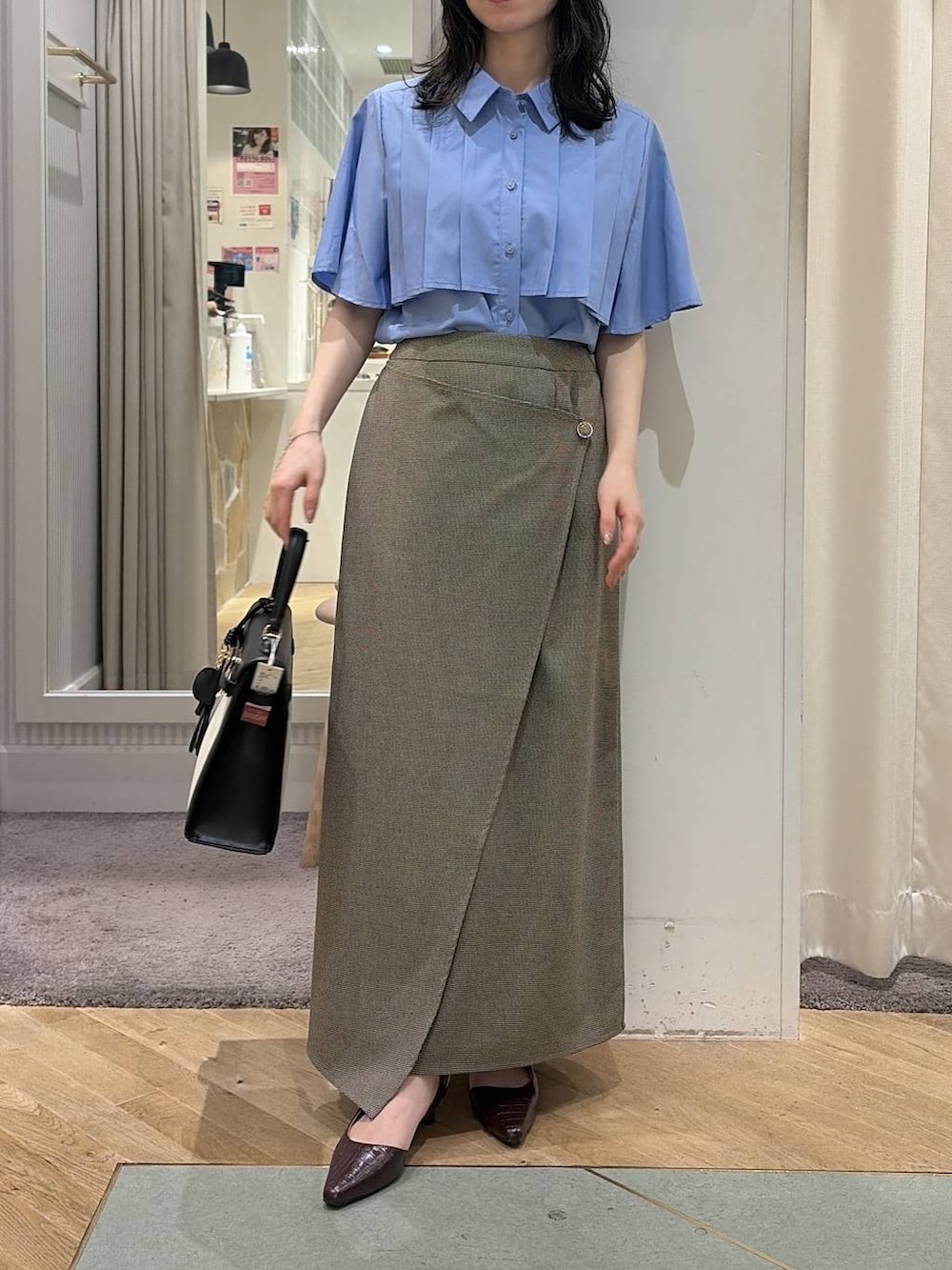 ベージュ系のスカート、ブルー系のシャツ/ブラウス、ブラウン系のパンプスを着用したレディースの夏コーディネートの5枚目の写真