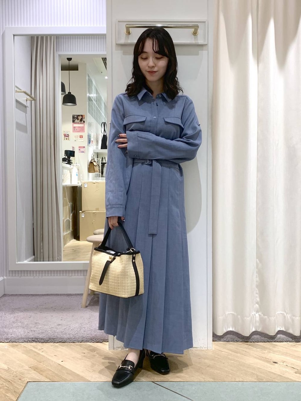 ブラック系のトートバッグ、ブルー系のワンピースを着用したレディースの春コーディネートの2枚目の写真