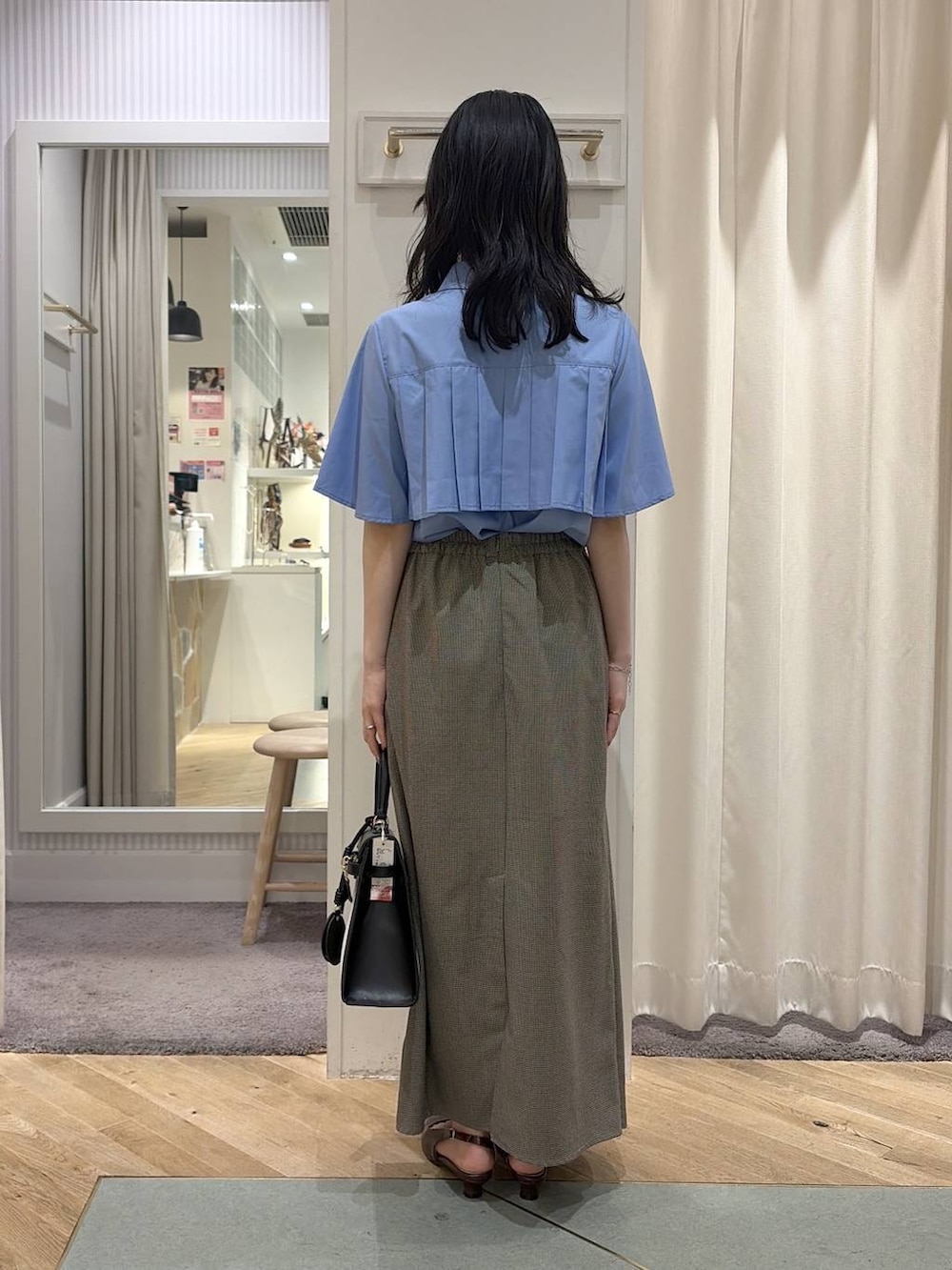 ベージュ系のスカート、ブルー系のシャツ/ブラウス、ブラウン系のパンプスを着用したレディースの夏コーディネートの4枚目の写真