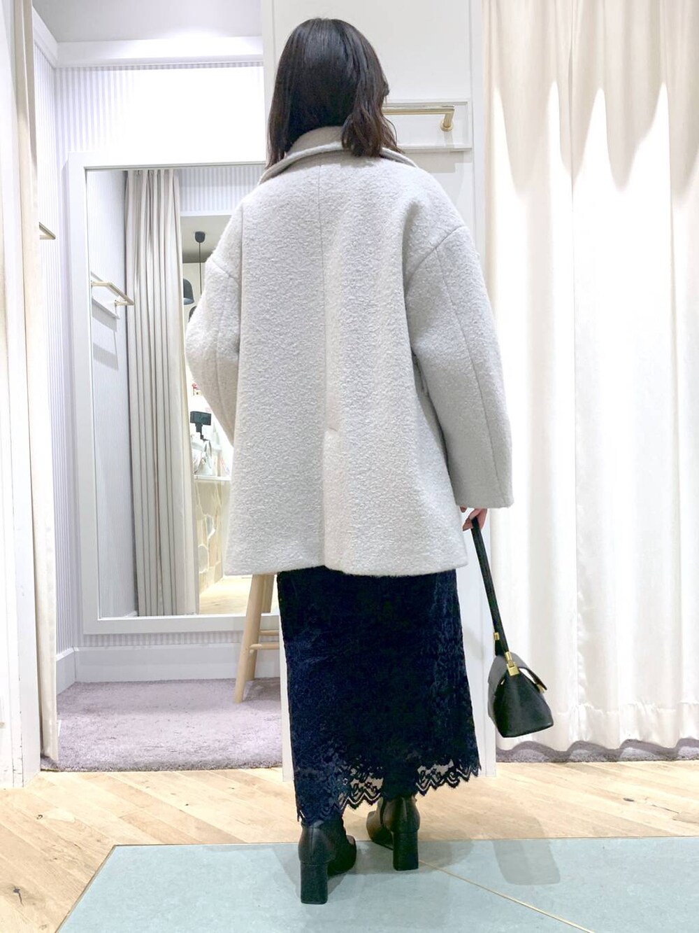 ブラック系のショルダーバッグ、グレー系のピーコート、ブラック系のブーツを着用したレディースの秋コーディネートの7枚目の写真