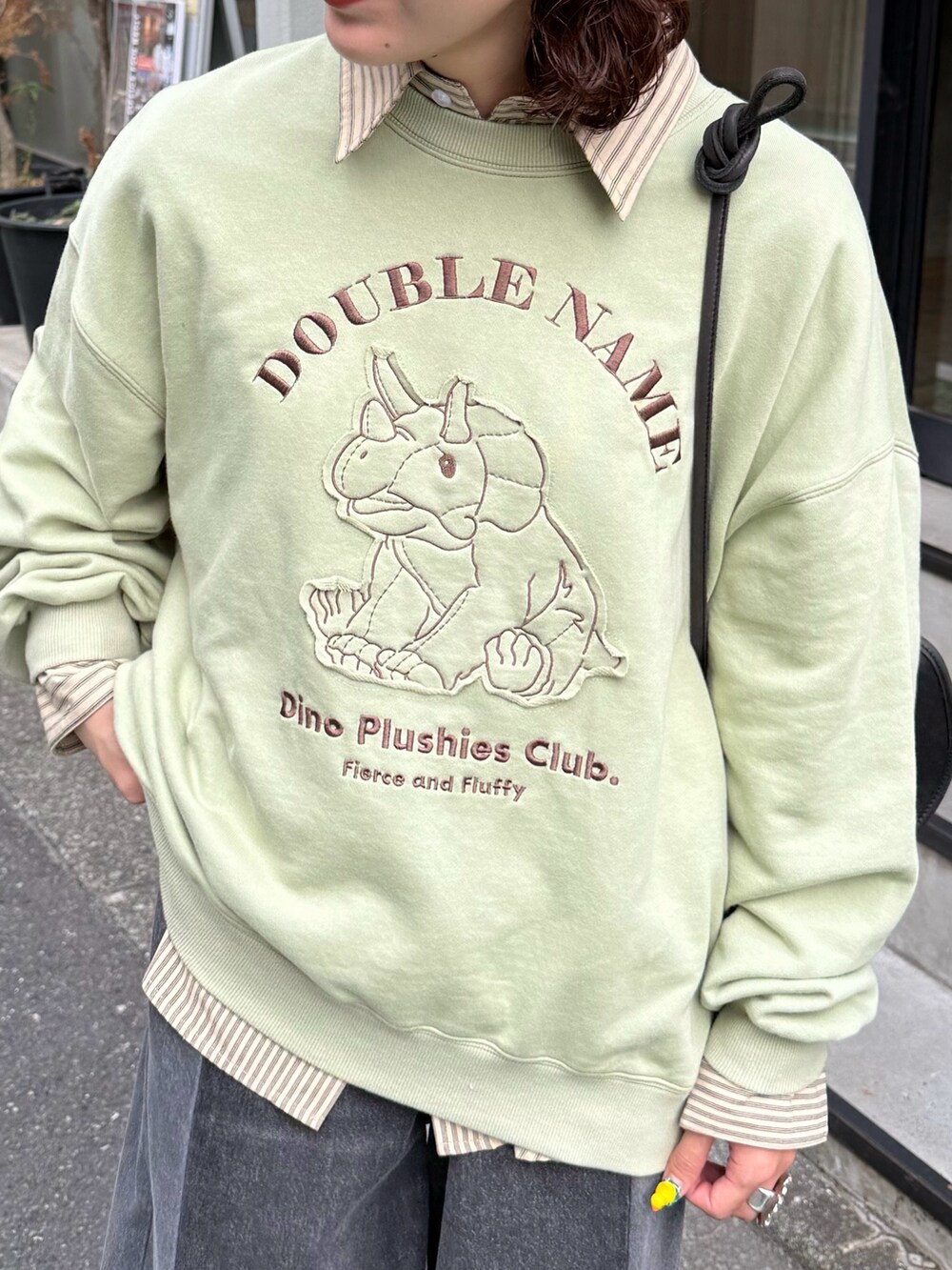 グリーン系のTシャツ/カットソー、ベージュ系のシャツ/ブラウス、ブラック系のデニムパンツを着用したレディースの秋コーディネートの3枚目の写真