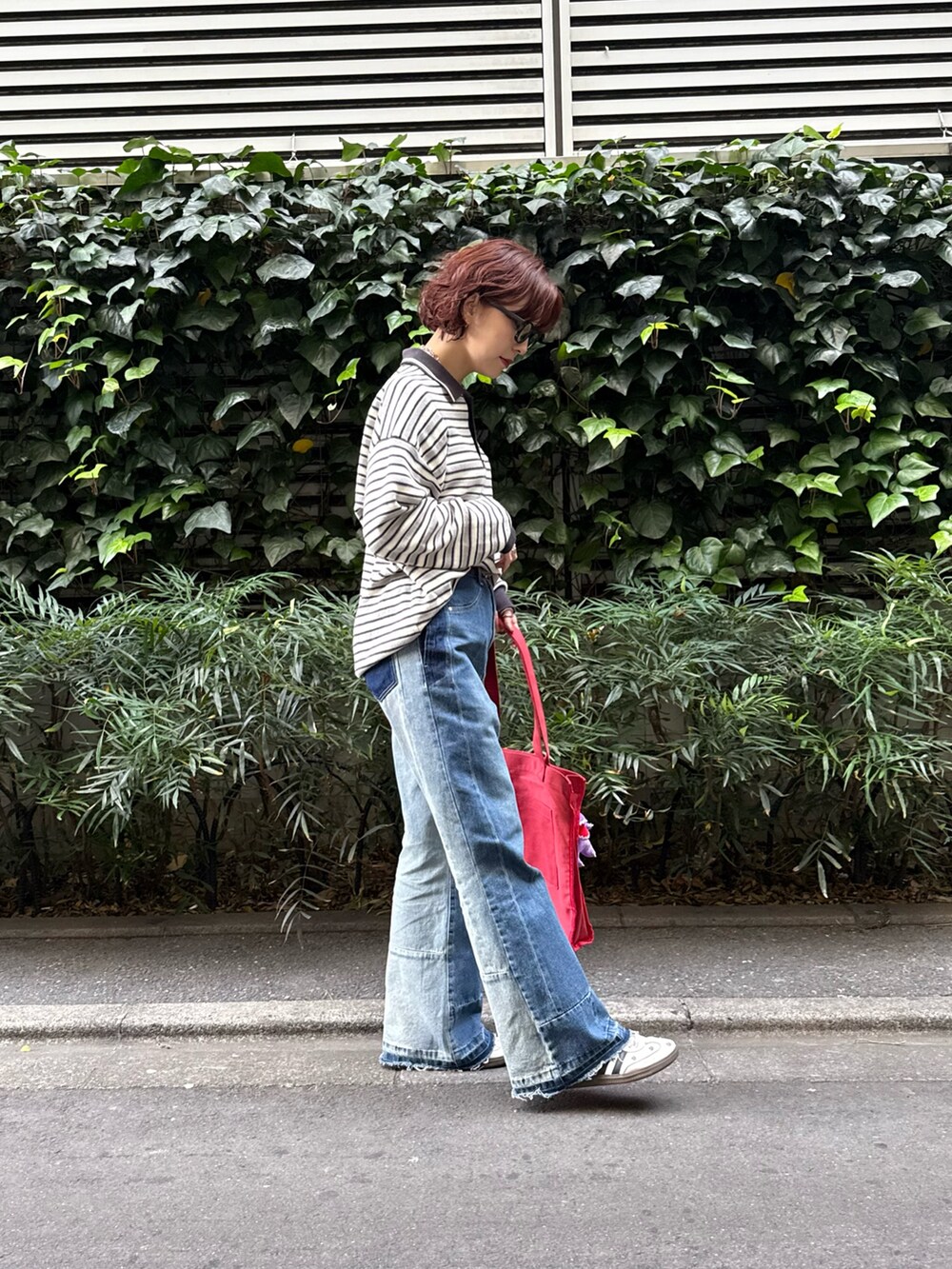 ブラック系のニット/セーター、ブルー系のその他パンツ、レッド系のトートバッグを着用したレディースの冬コーディネートの2枚目の写真