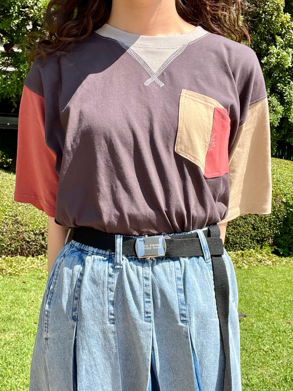 ブルー系のデニムスカート、ブラック系のTシャツ/カットソー、ブラック系のベルトを着用したレディースの夏コーディネートの3枚目の写真