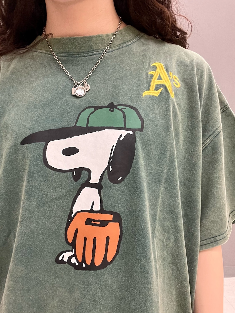 グリーン系のTシャツ/カットソー、ブルー系のデニムパンツ、ピンク系のベルトを着用したレディースの春コーディネートの6枚目の写真