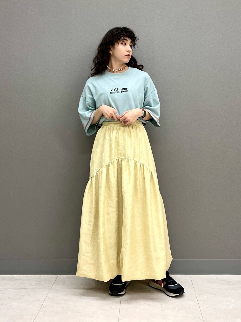 ブルー系のTシャツ/カットソー、イエロー系のスカートを着用したレディースの春コーディネートの4枚目の写真