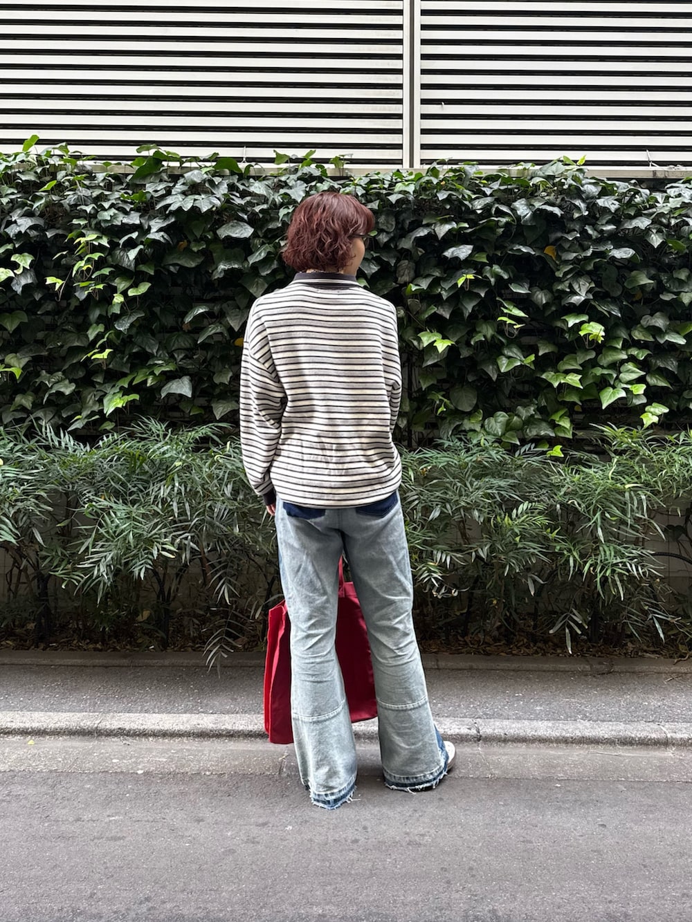 ブラック系のニット/セーター、ブルー系のその他パンツ、レッド系のトートバッグを着用したレディースの冬コーディネートの3枚目の写真