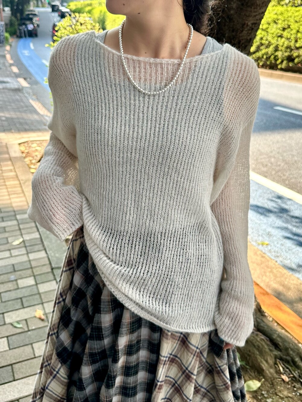 ブラック系のスカート、ホワイト系のニット/セーターを着用したレディースの秋コーディネートの3枚目の写真