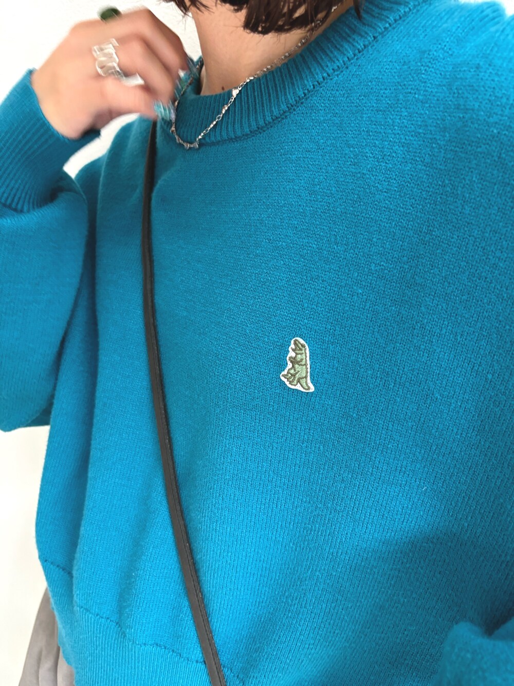 ブルー系のニット/セーター、グレー系のその他パンツを着用したレディースの秋コーディネートの4枚目の写真