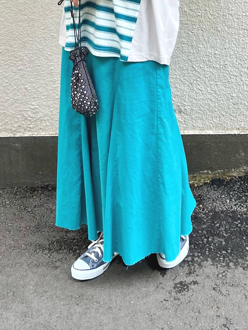 ホワイト系のTシャツ/カットソー、ブルー系のスカート、ブラック系のタンクトップを着用したレディースの春コーディネートの6枚目の写真