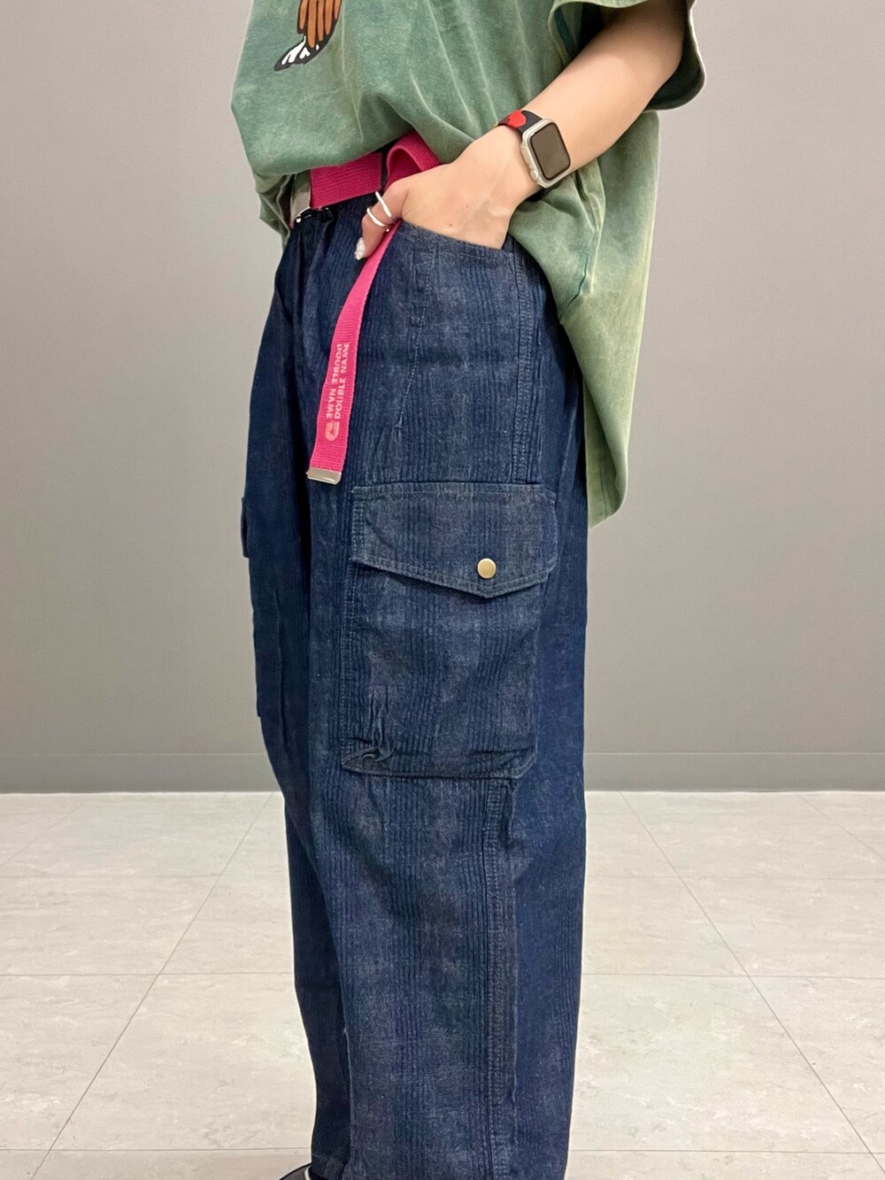 グリーン系のTシャツ/カットソー、ブルー系のデニムパンツ、ピンク系のベルトを着用したレディースの春コーディネートの9枚目の写真