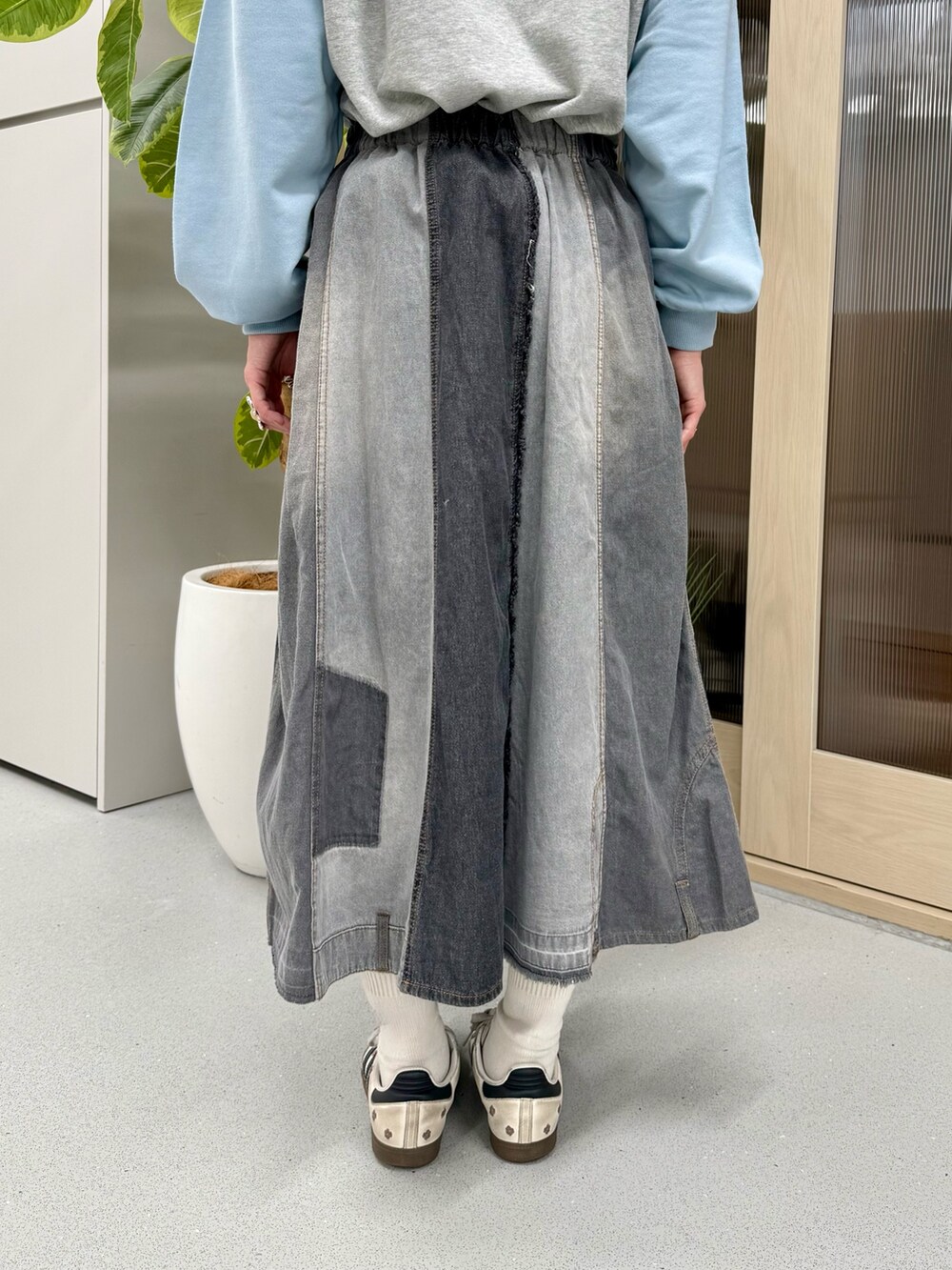 ブルー系のTシャツ/カットソー、ブラック系のスカートを着用したレディースの冬コーディネートの9枚目の写真