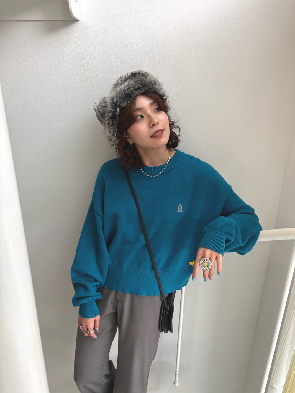 ブルー系のニット/セーター、グレー系のその他パンツを着用したレディースの秋コーディネートの3枚目の写真