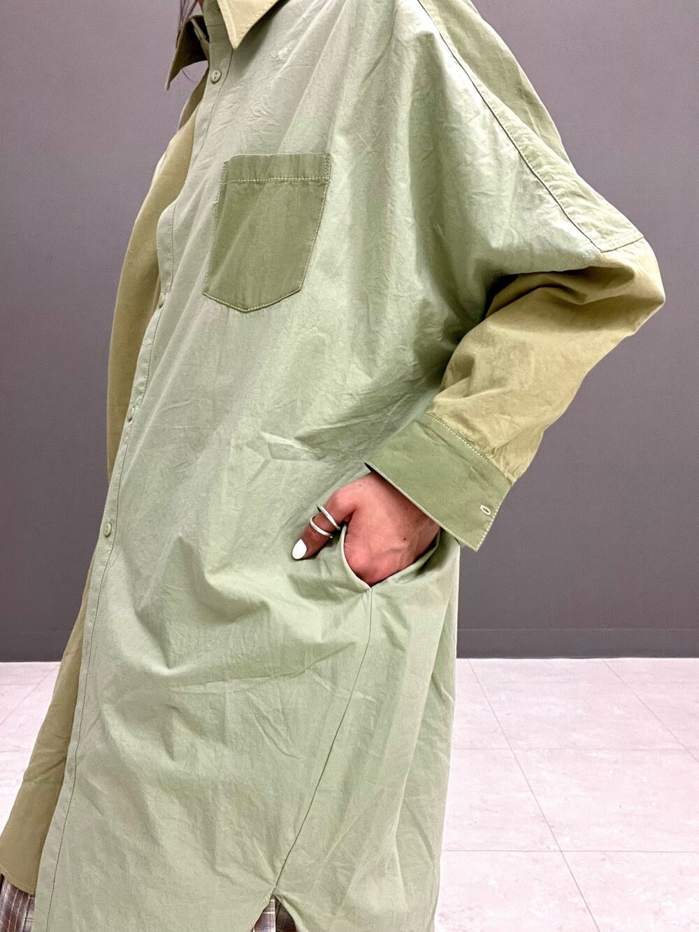 ベージュ系のスカート、グリーン系のワンピースを着用したレディースの春コーディネートの3枚目の写真